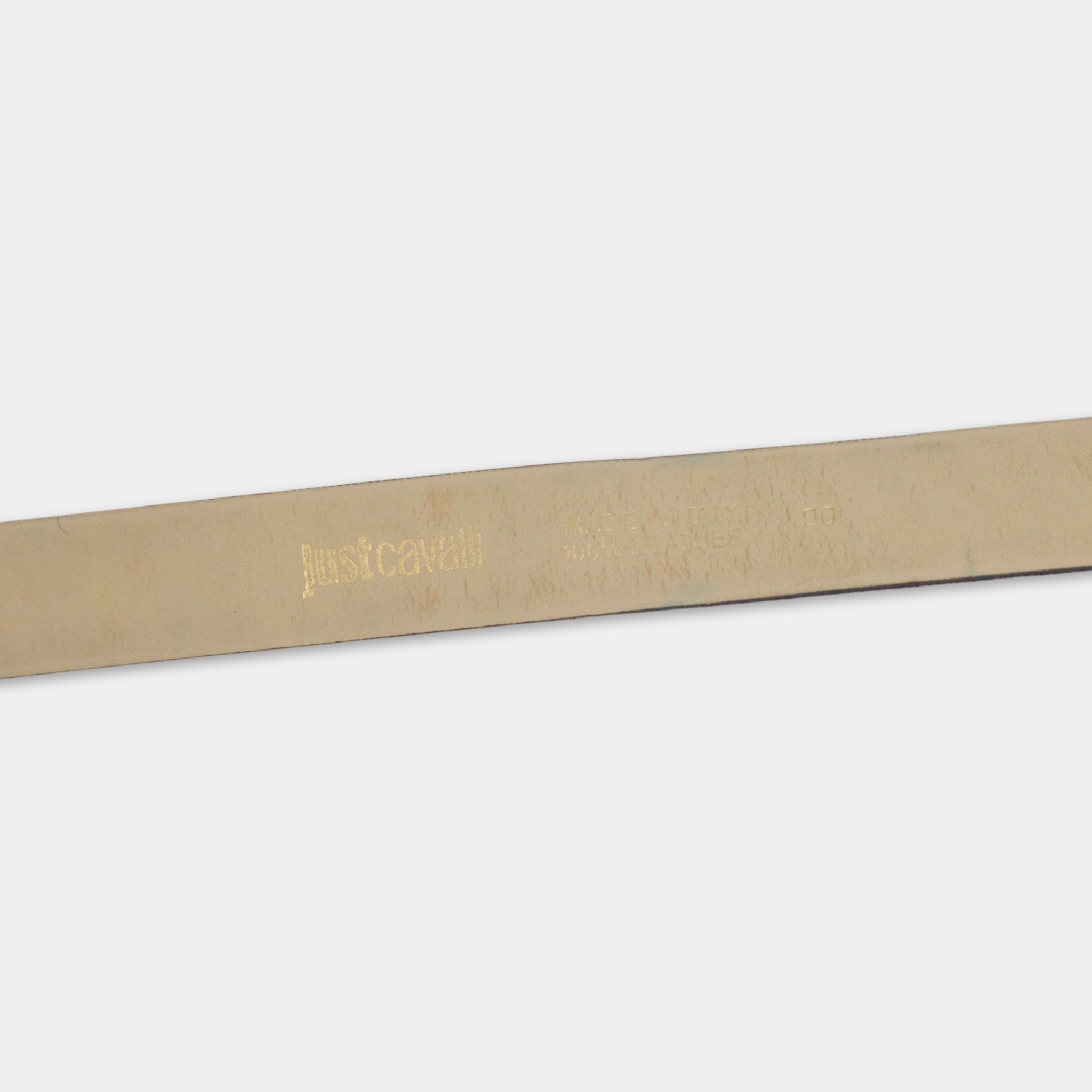 A close-up view of a tan leather belt with embossed text and a logo.