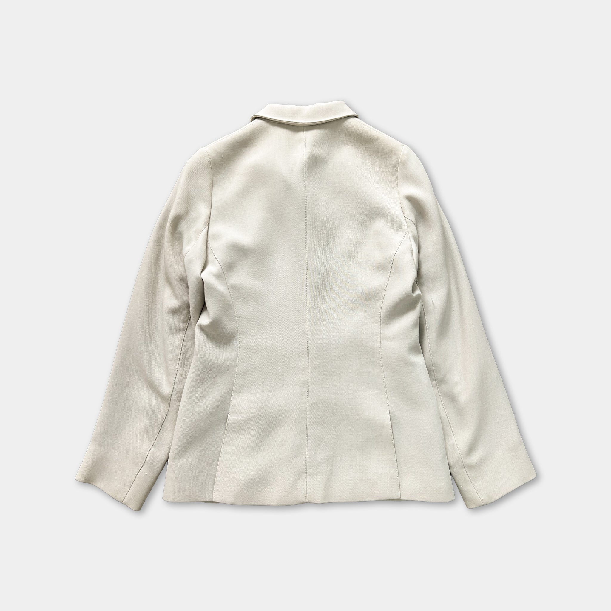 A plain, light-colored blazer is shown against a white background.