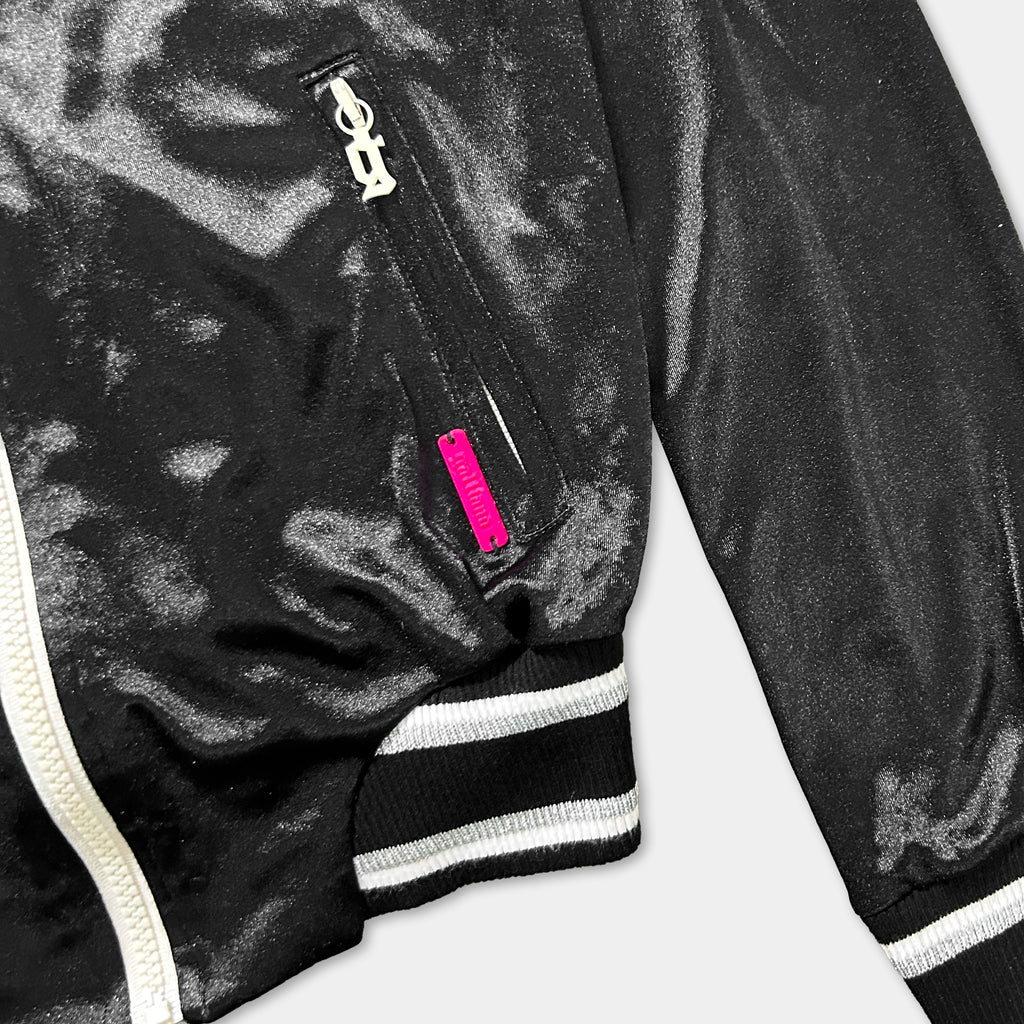 A close-up view of a black jacket with a zipper and a pink tag.