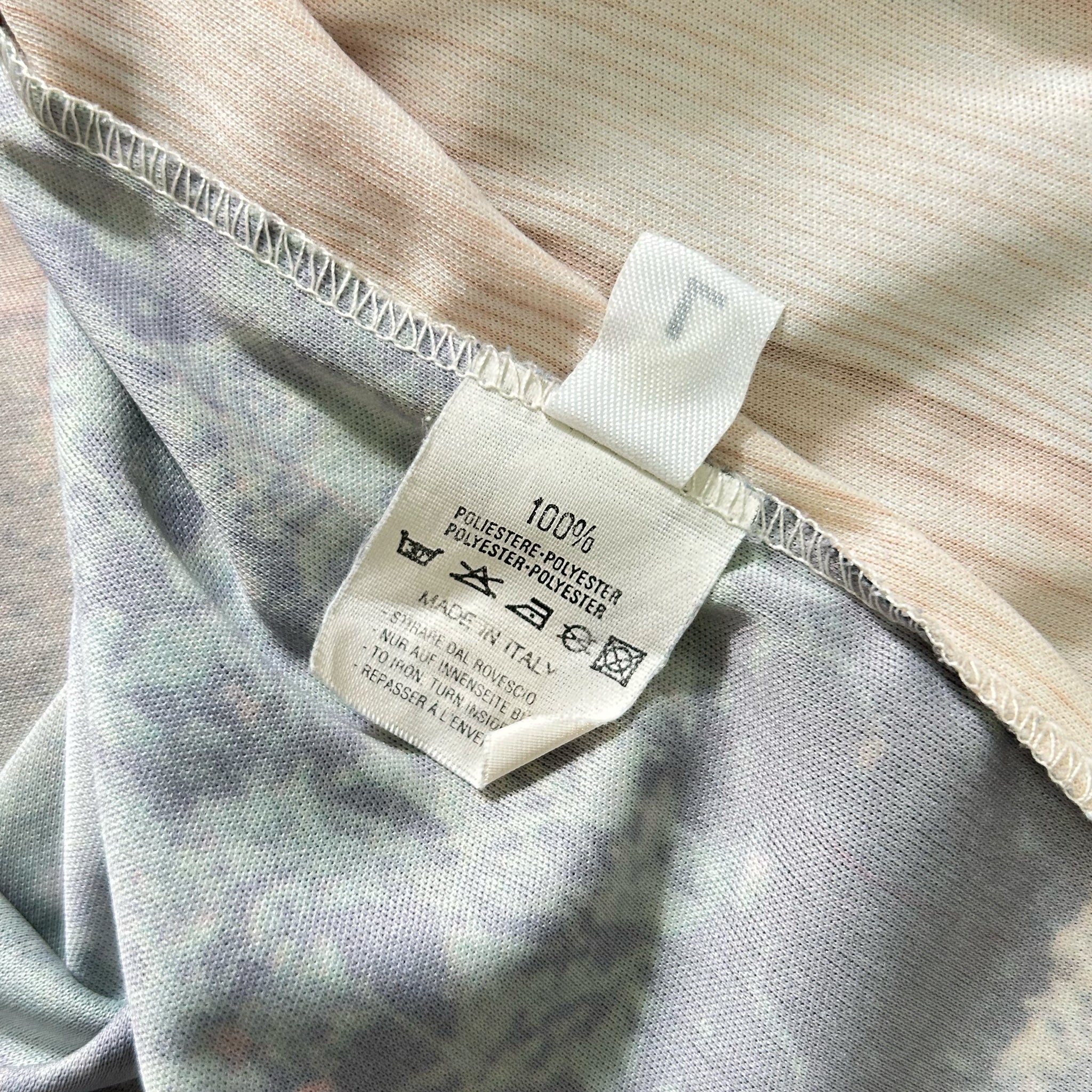 a close-up view of a fabric label with text and symbols, indicating the material and care instructions for the garment.