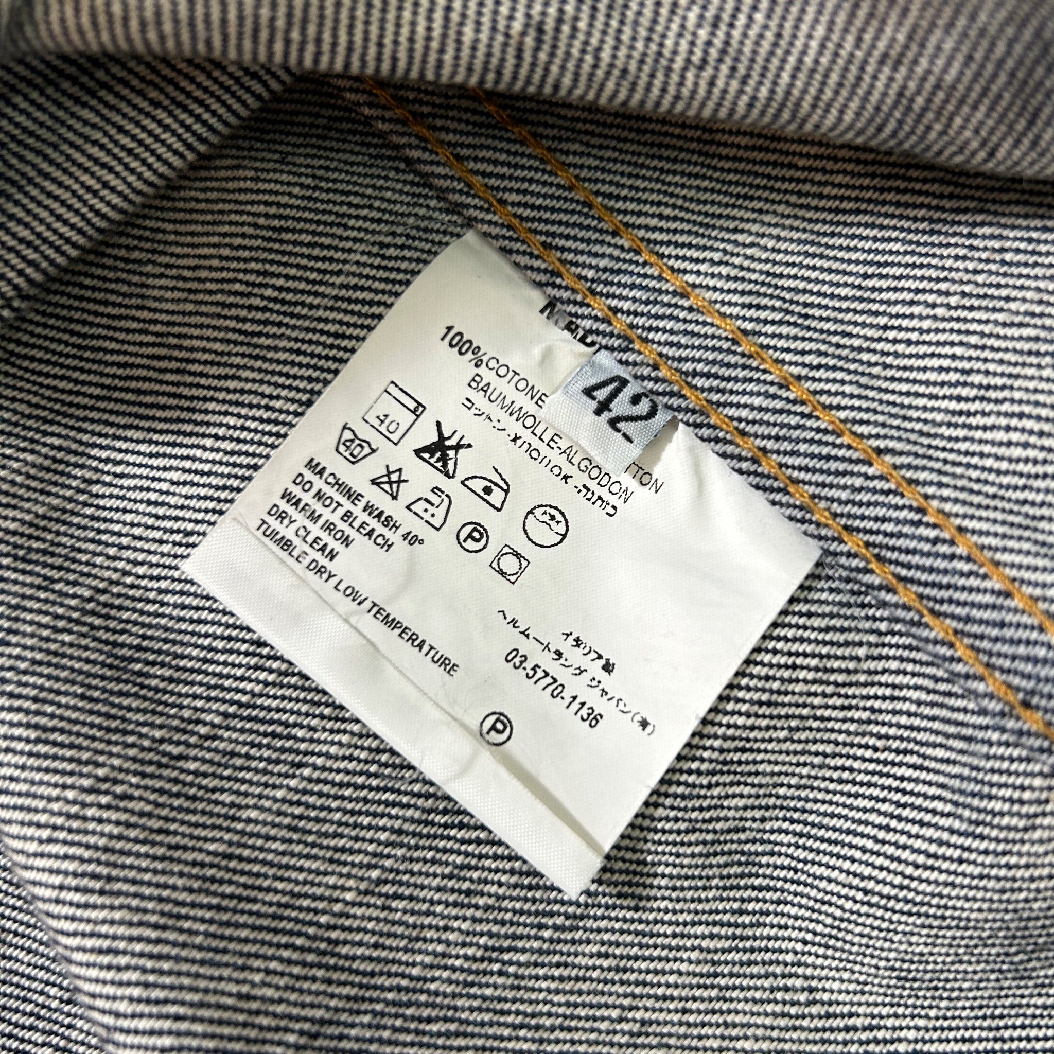 a close-up view of a denim fabric, specifically a pair of jeans, with a label attached to it. The label provides information about the fabric, such as the material and the brand.