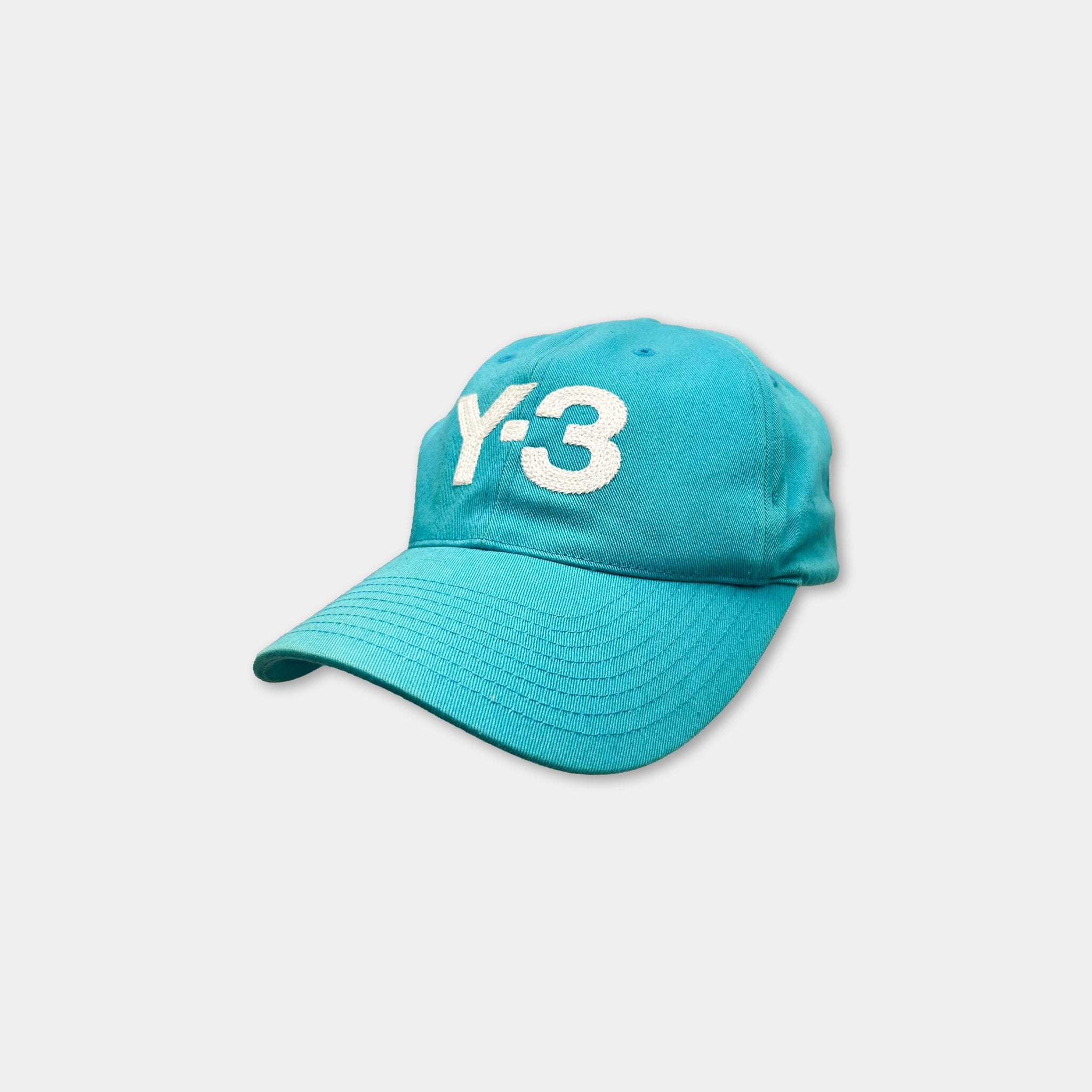 A turquoise baseball cap with the number '3' printed on it.