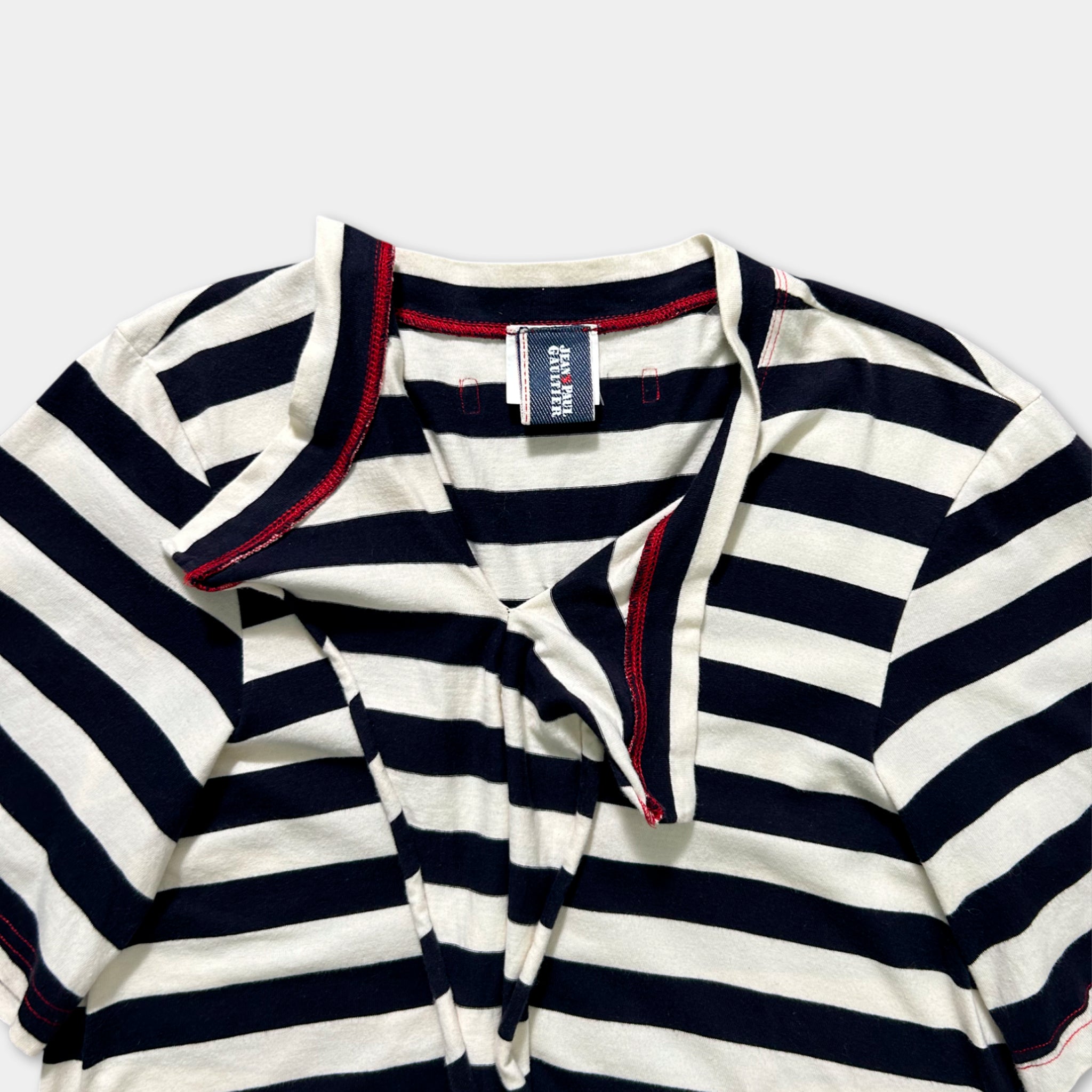 A striped shirt with a red collar and a white tag on the collar.