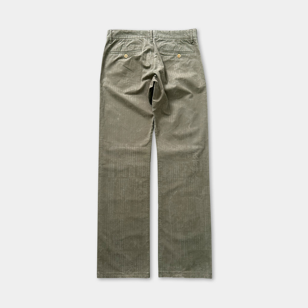 A pair of olive green corduroy pants with a button waistband and two pockets.