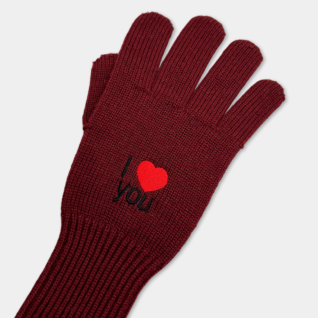 A pair of burgundy knit gloves with a red heart embroidered on the palm.