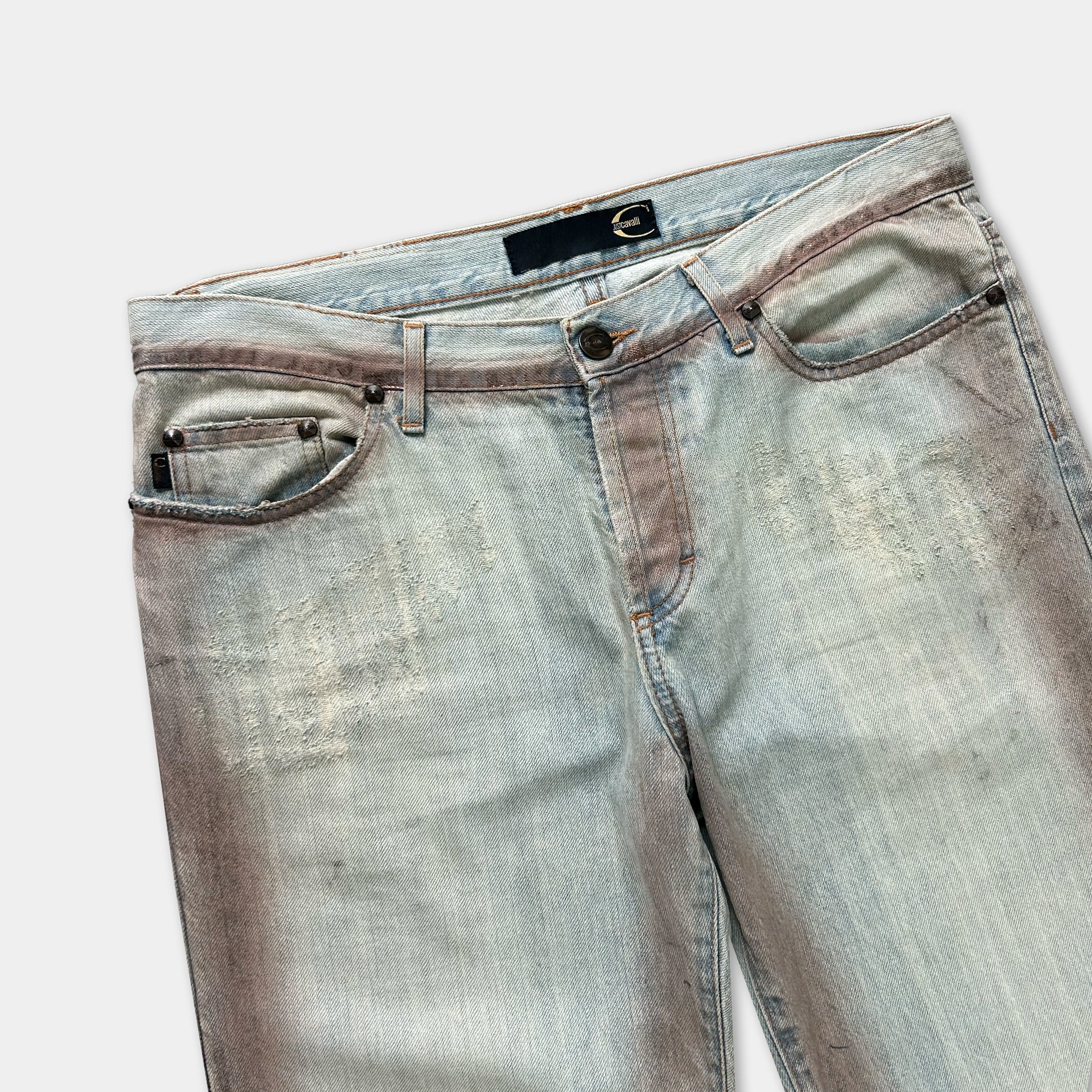 A pair of well-worn, faded blue jeans with visible wear and tear.