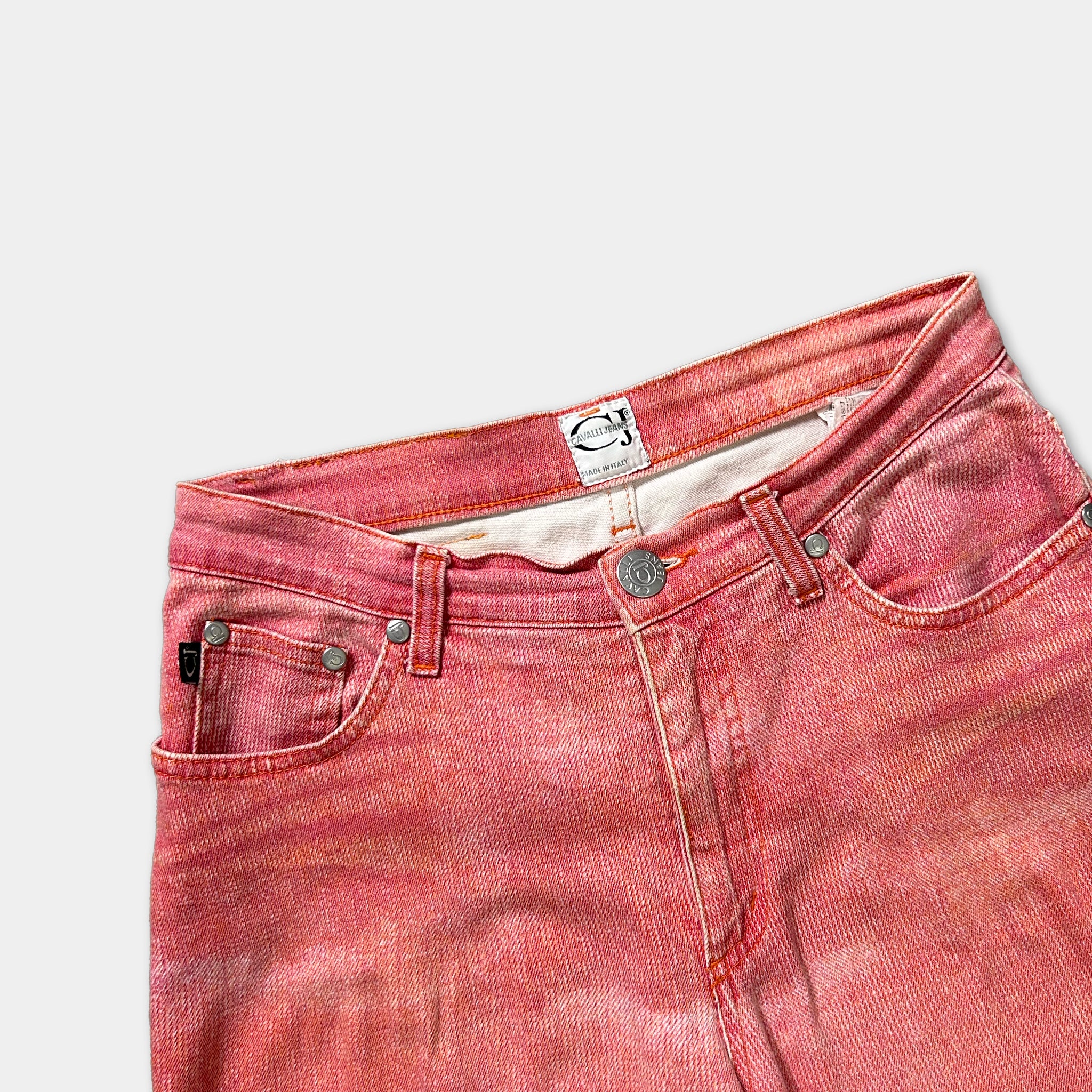 A pair of red jeans with a label on the waistband.