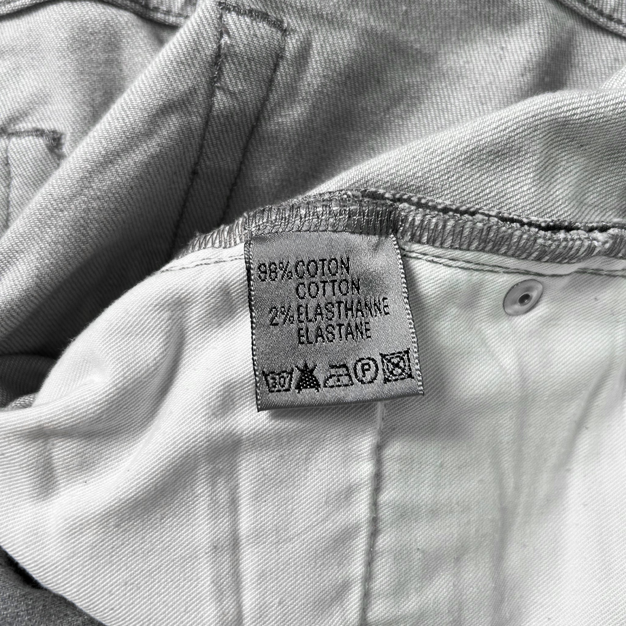 A close-up of a fabric label on a pair of jeans, indicating the material and care instructions.