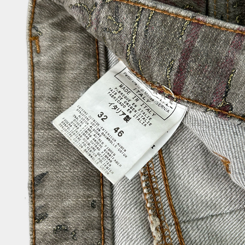 a close-up view of a label attached to a pair of gray jeans, with the label providing information about the jeans.
