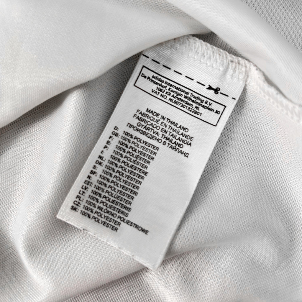 a close-up view of a white fabric label with text and numbers, indicating the material and production details of the fabric.