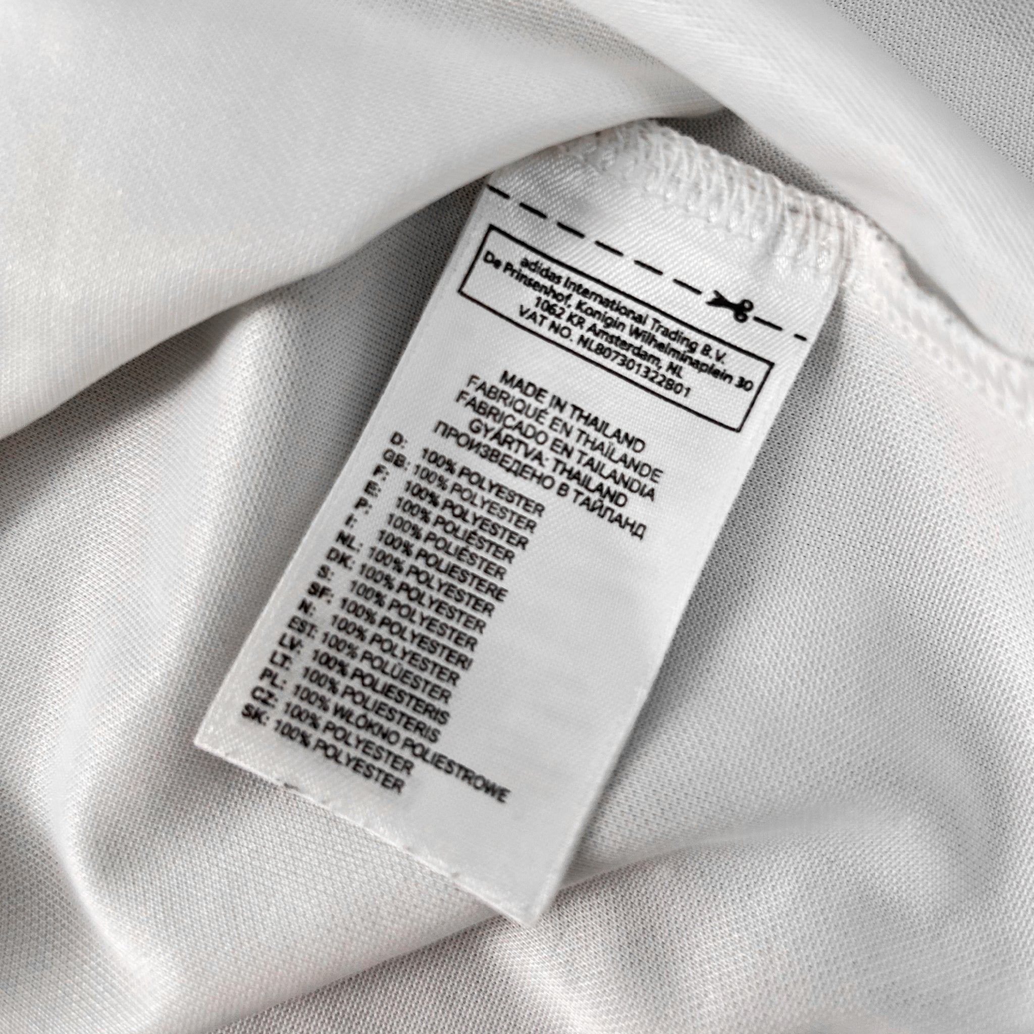 a close-up view of a white fabric label with text and numbers, indicating the material and production details of the fabric.