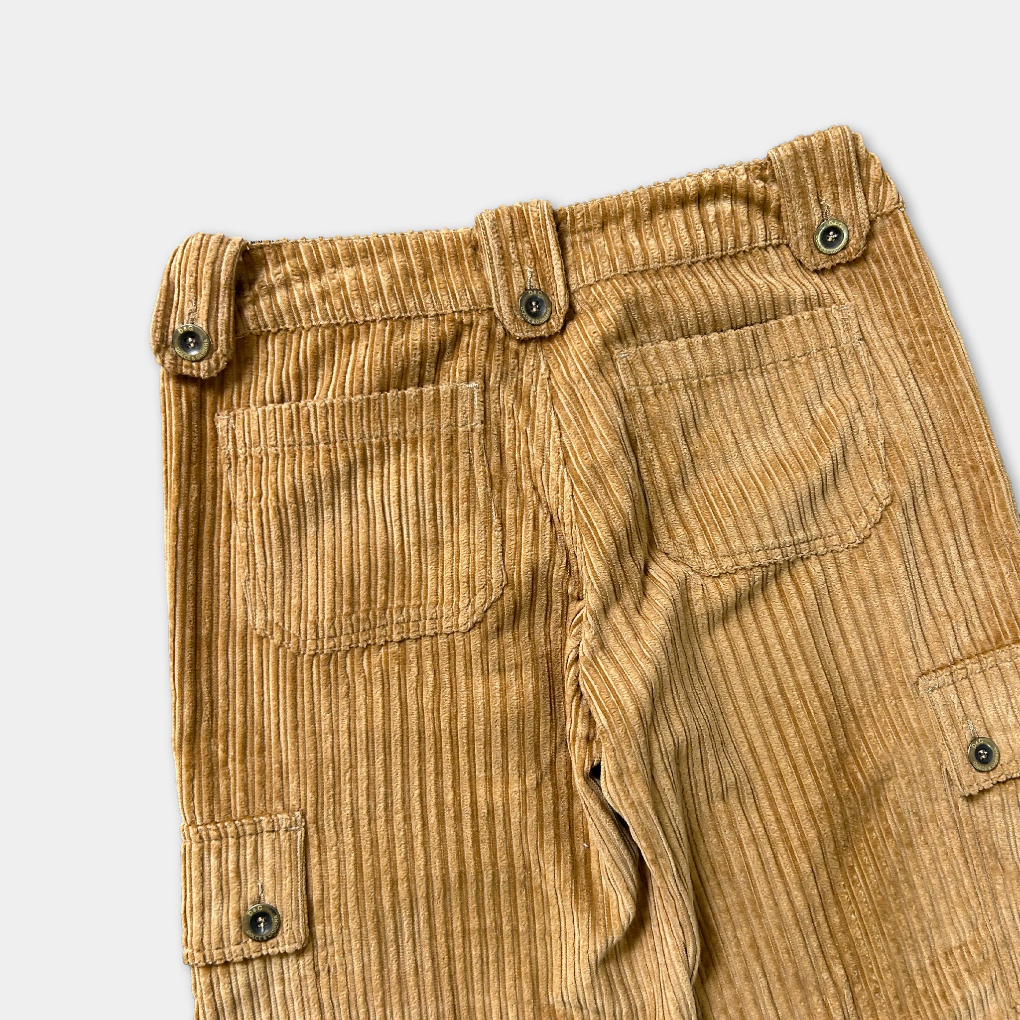 a pair of tan corduroy pants with a button closure and two pockets.