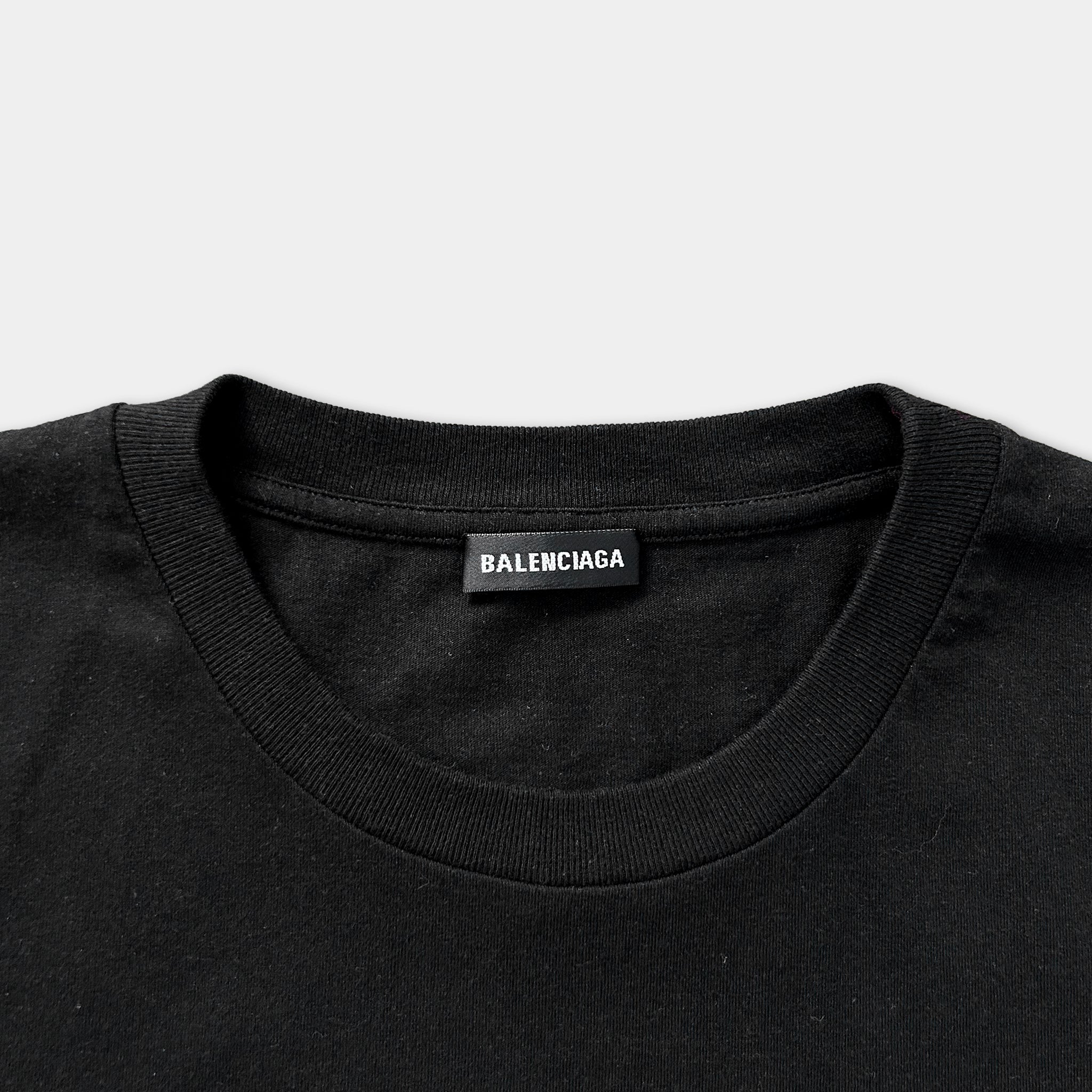 A black t-shirt with a label that says "BALENCIAGA" on the collar.