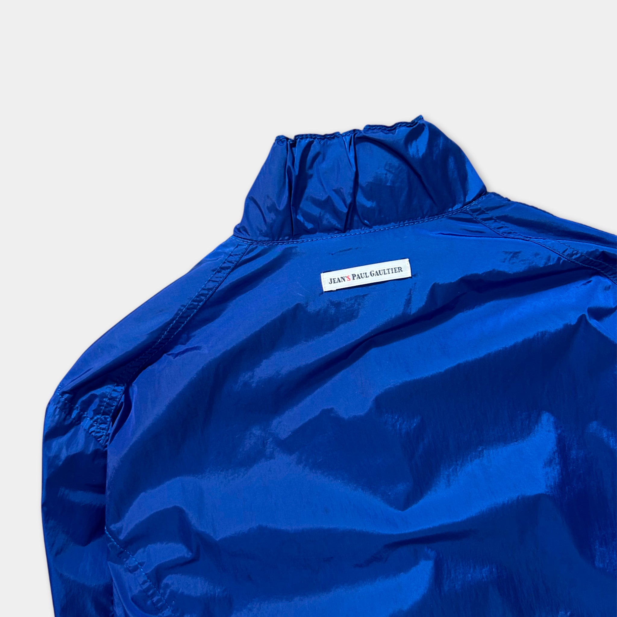 A close-up view of a blue jacket with a label on the back.