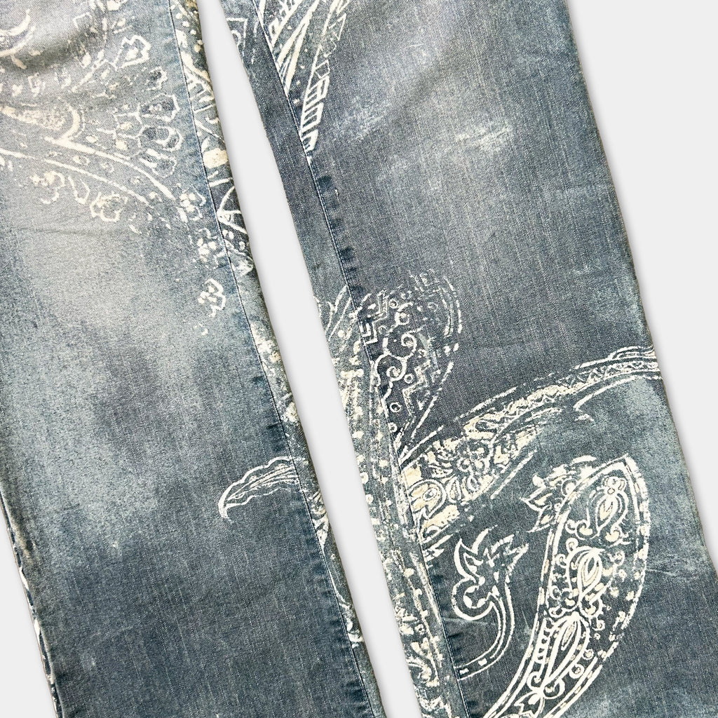 a pair of blue jeans with a white paisley pattern on the fabric.