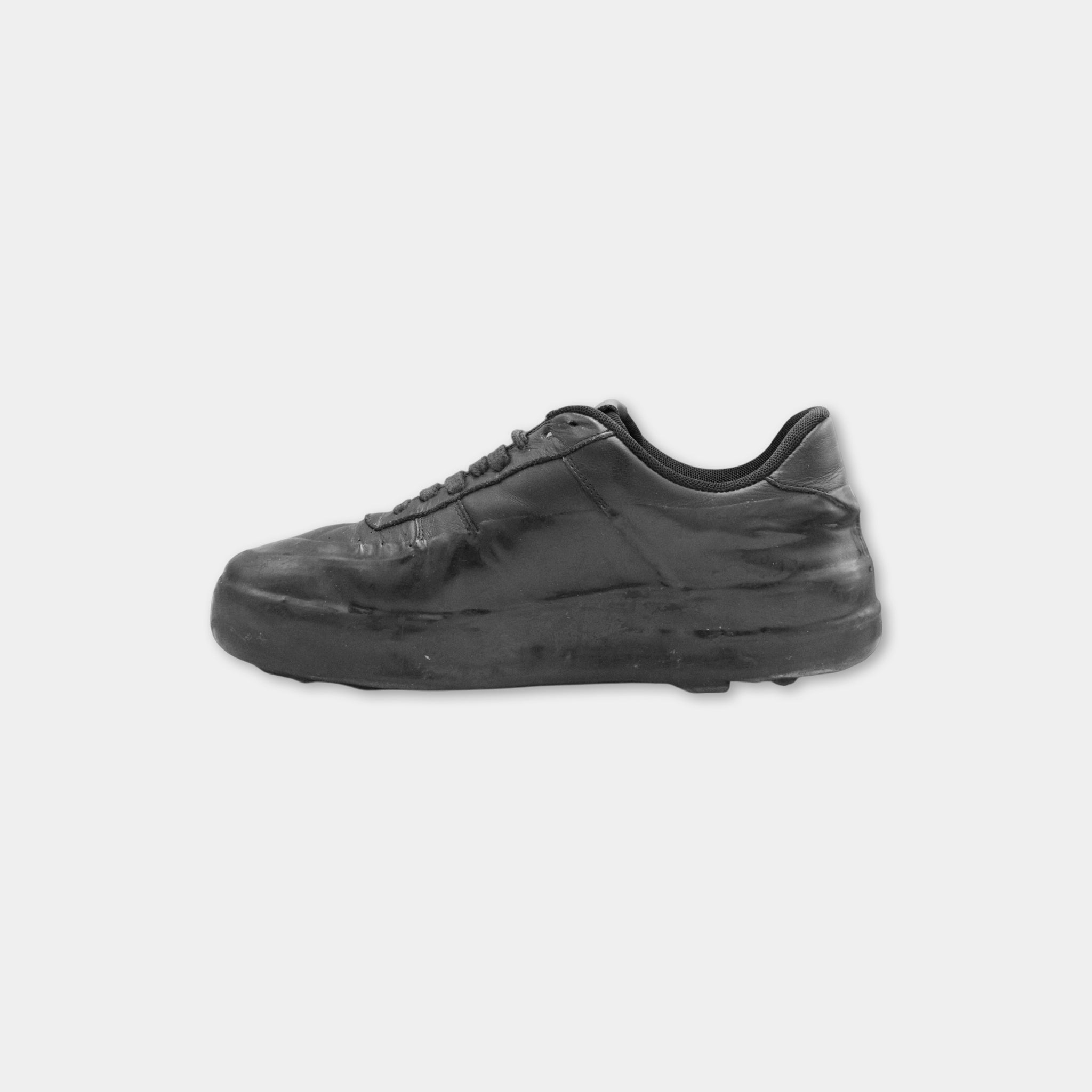 A black and white image of a worn and dirty shoe.