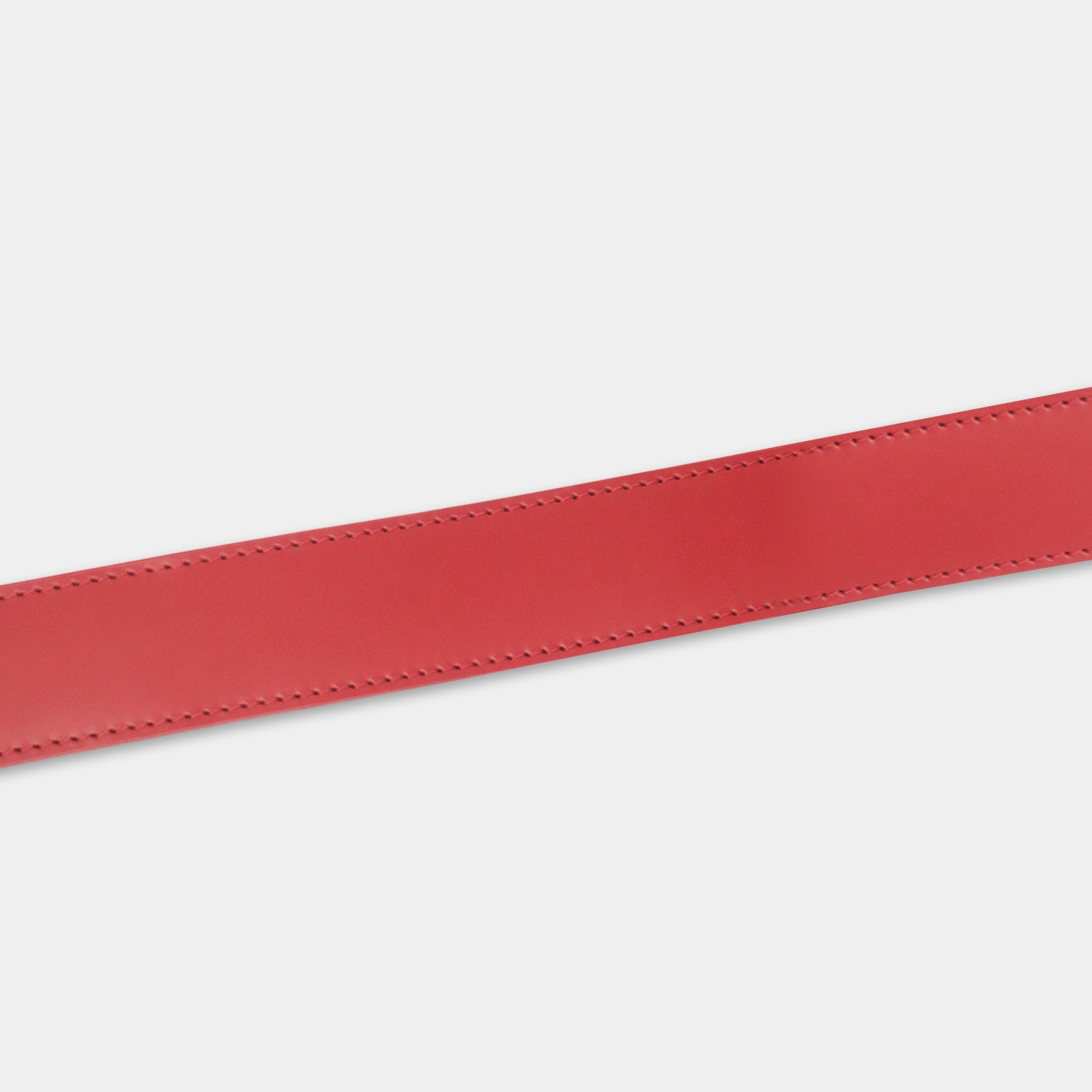 A red leather belt with a simple, clean design.