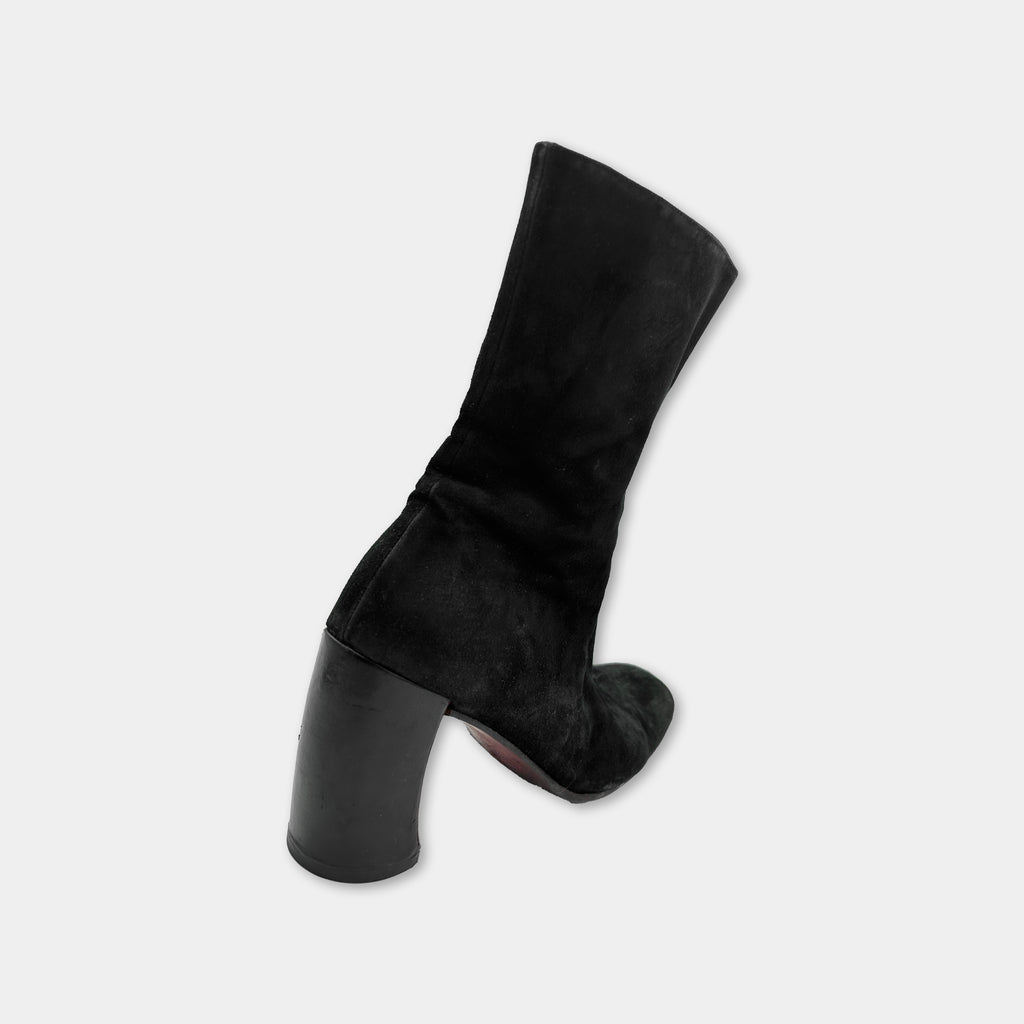A black suede high-heeled boot is shown against a white background.