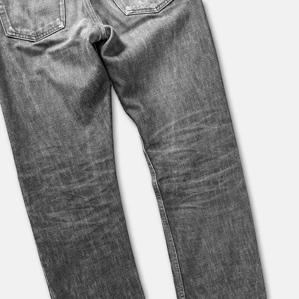 A pair of well-worn, gray jeans with visible signs of use and wear.