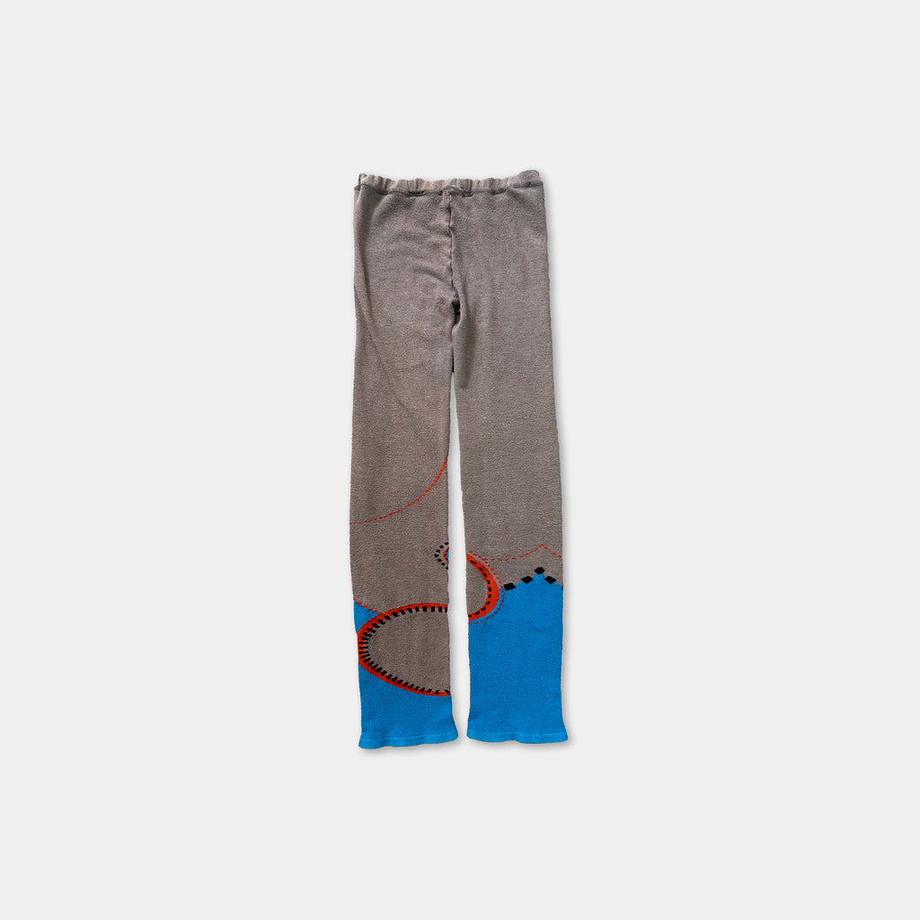 A pair of gray pants with blue and orange designs on the sides.