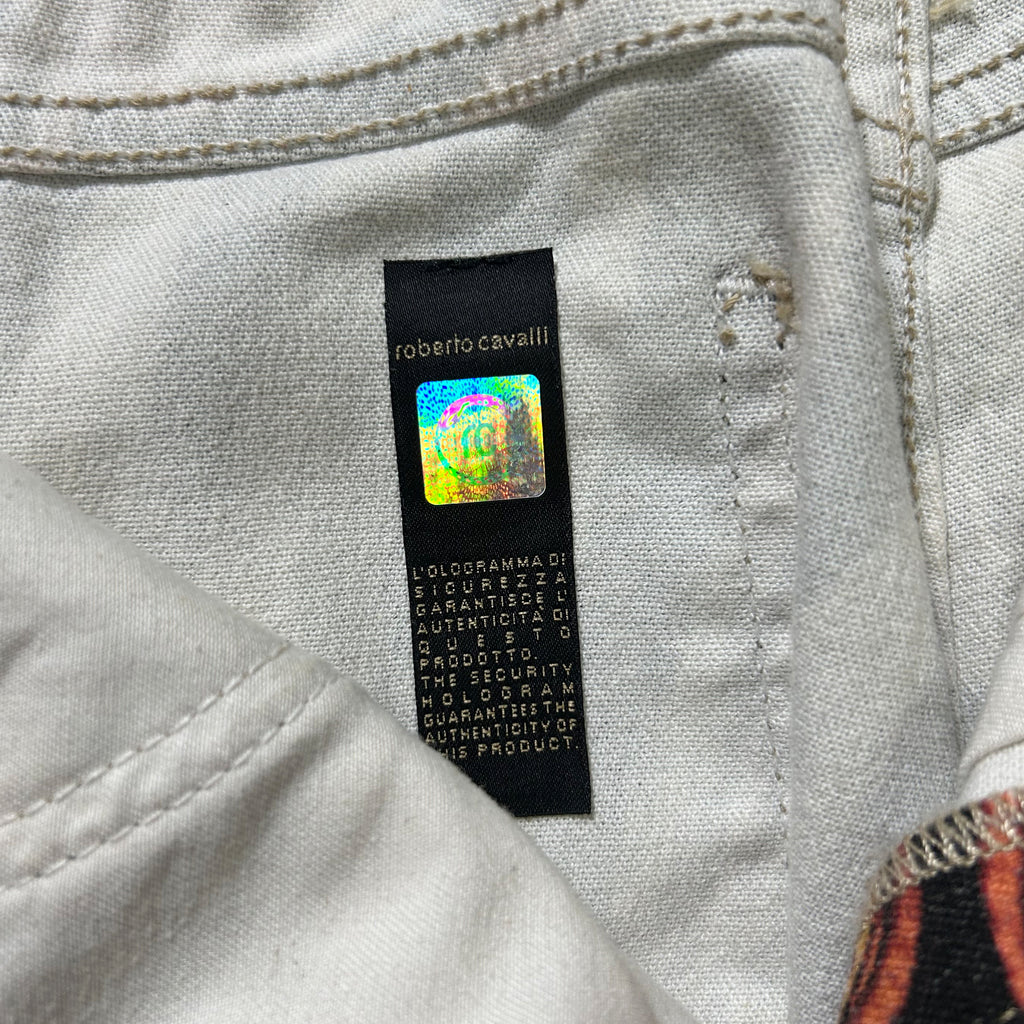 a close-up view of a white fabric, possibly a piece of clothing, with a black label attached to it. The label appears to contain text and possibly a logo or branding, but the image does not contain any text that can be described in fewer than 500 characters.