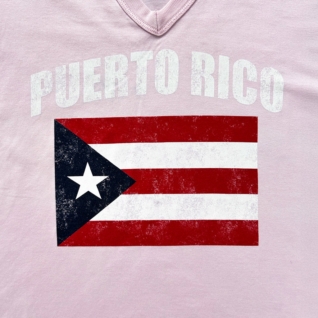 A pink T-shirt with the text "PUERTO RICO" printed on it, along with a graphic of the Puerto Rican flag.