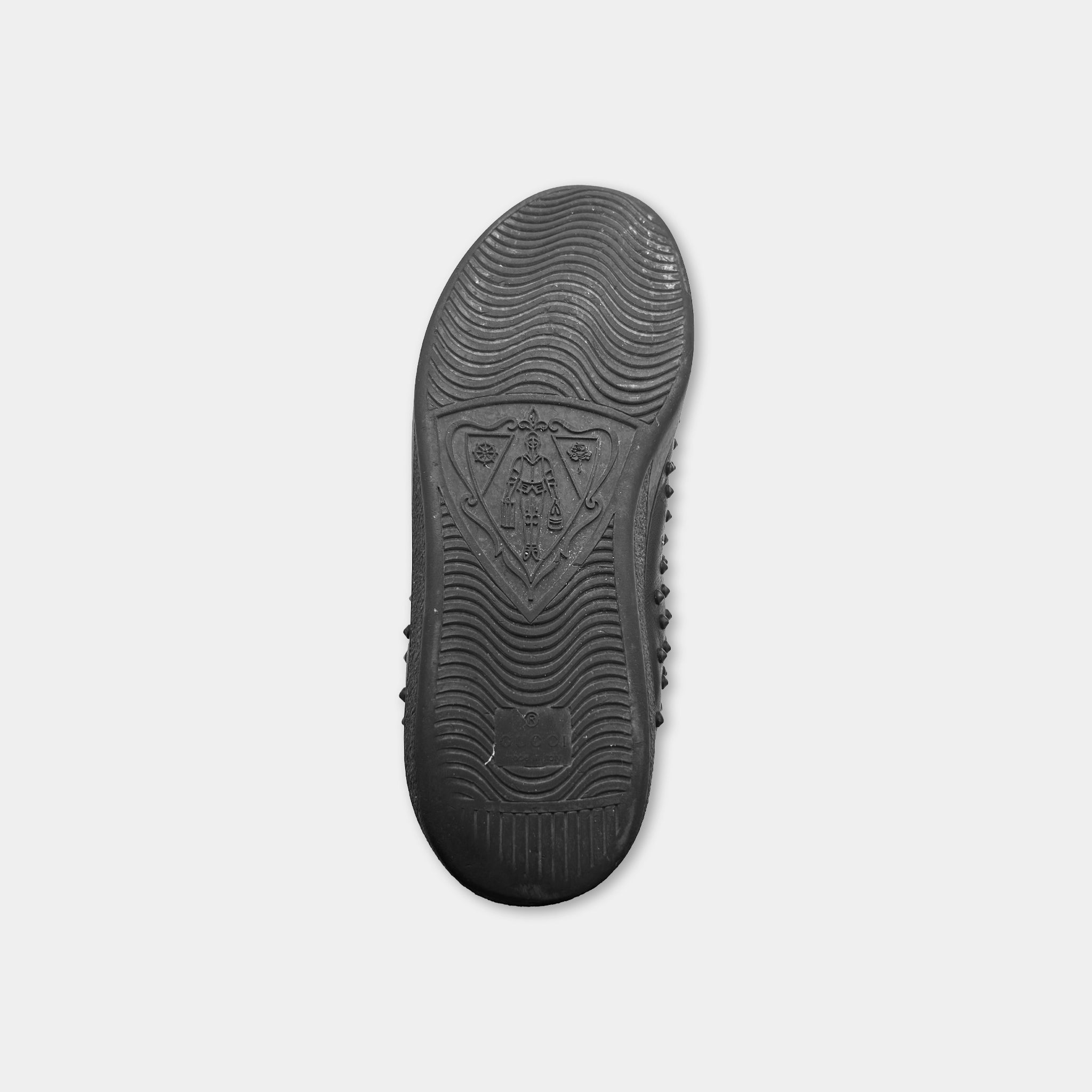 A black rubber sole of a shoe is shown against a white background.