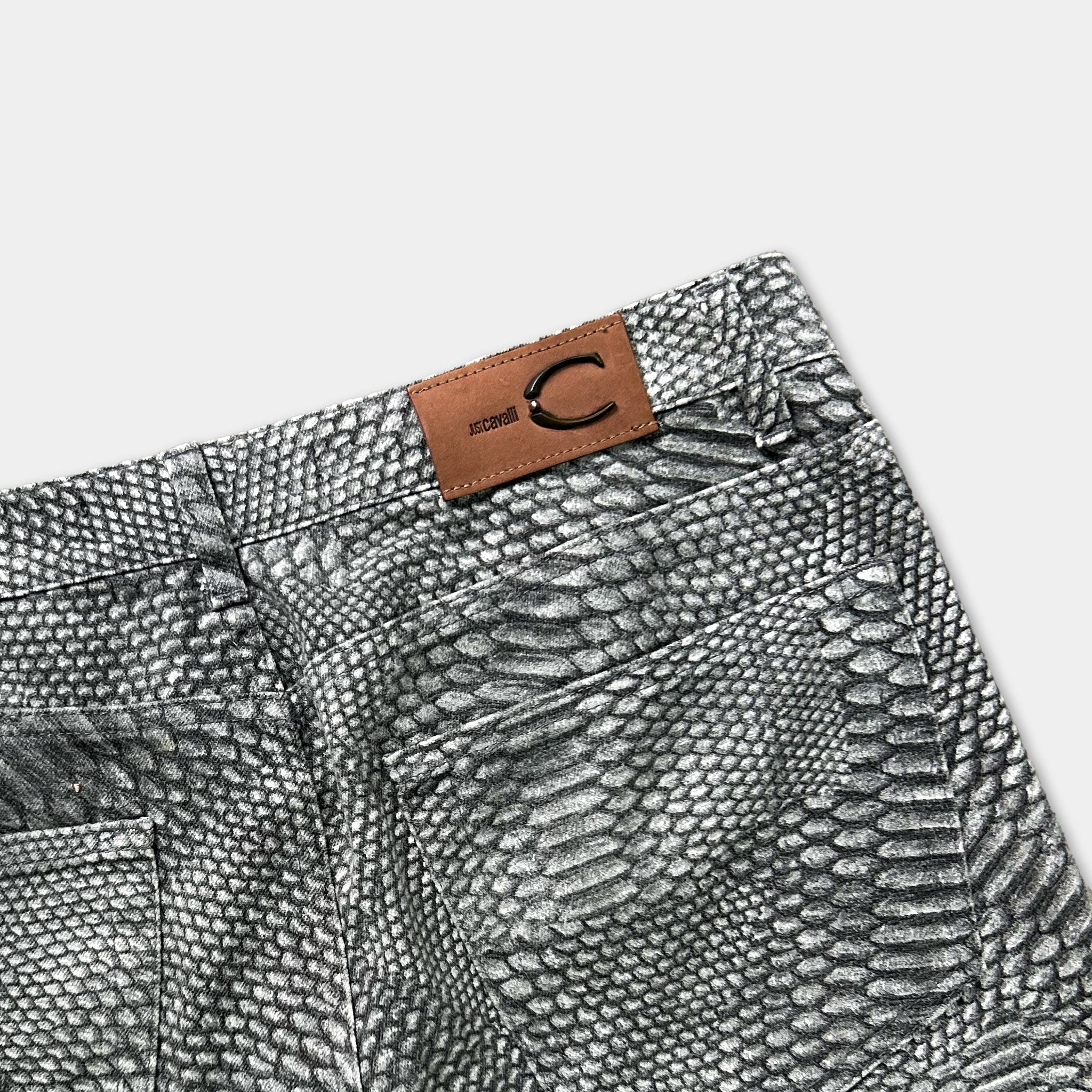 a pair of gray and white patterned jeans with a brown leather patch on the back pocket.