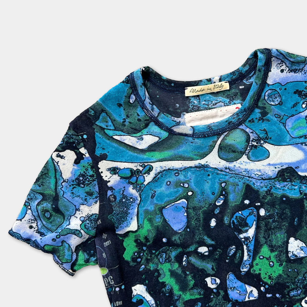 a colorful, abstract patterned t-shirt with a blue and green color scheme.