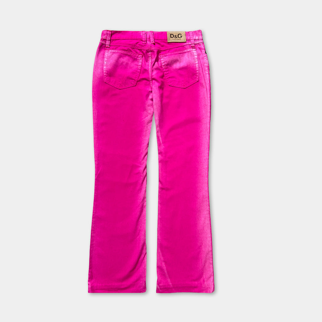 A pair of bright pink high-waisted jeans with a label on the waistband.