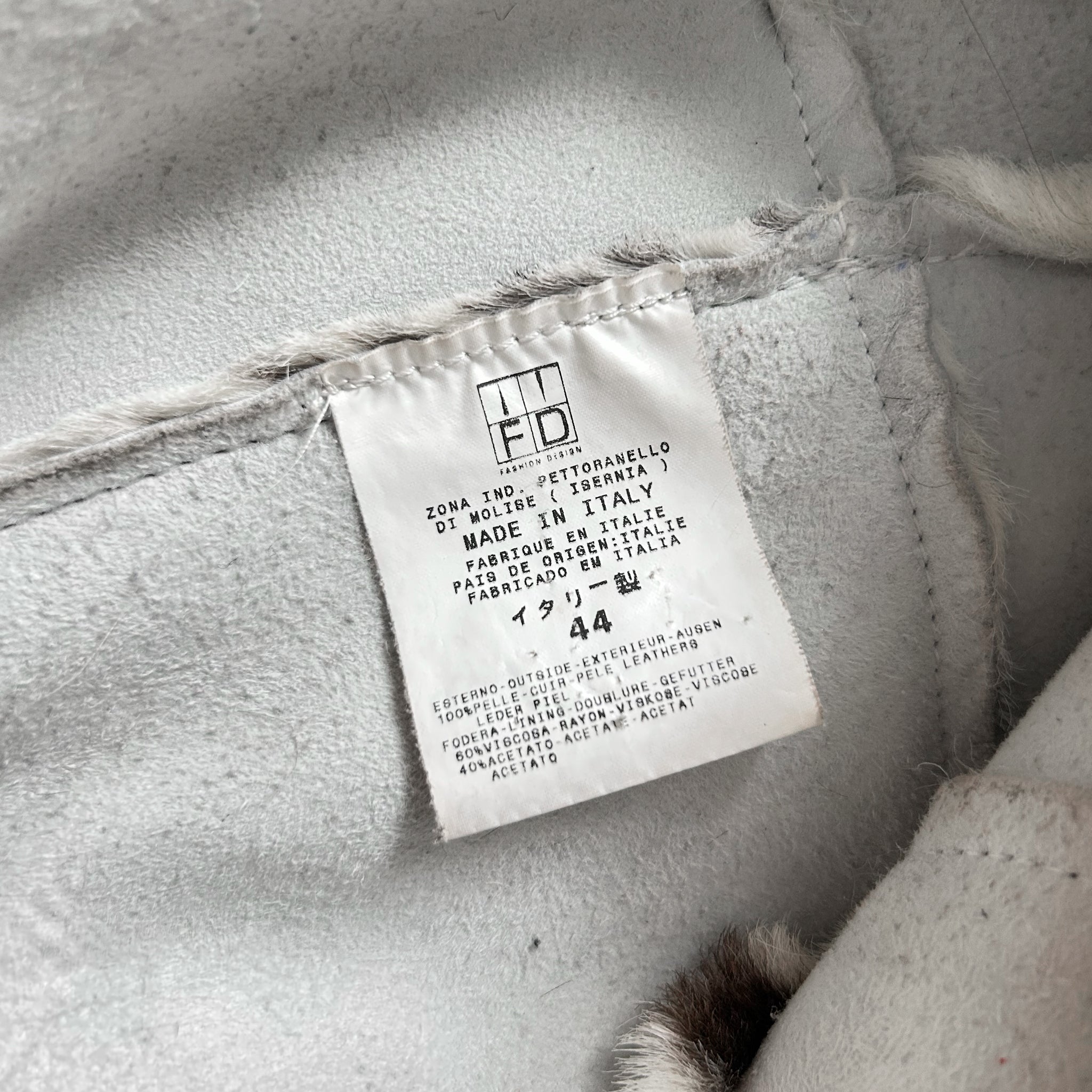 a close-up view of a white label with text on it, attached to a fabric surface.