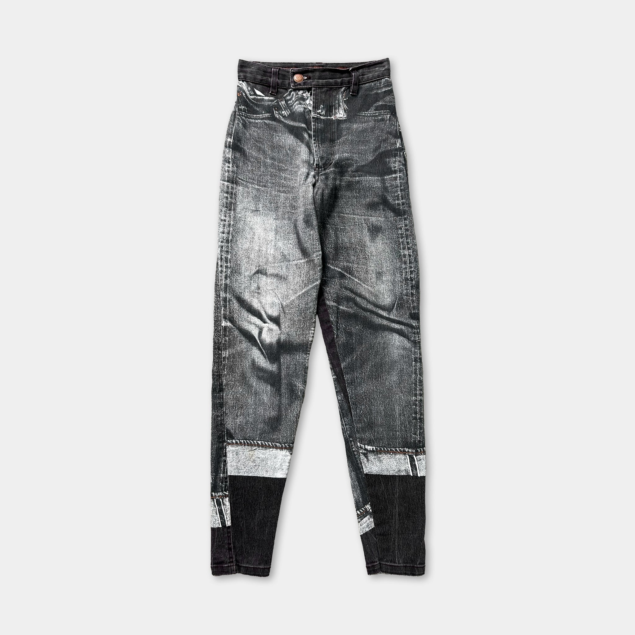 A pair of black and white jeans with a distressed appearance.
