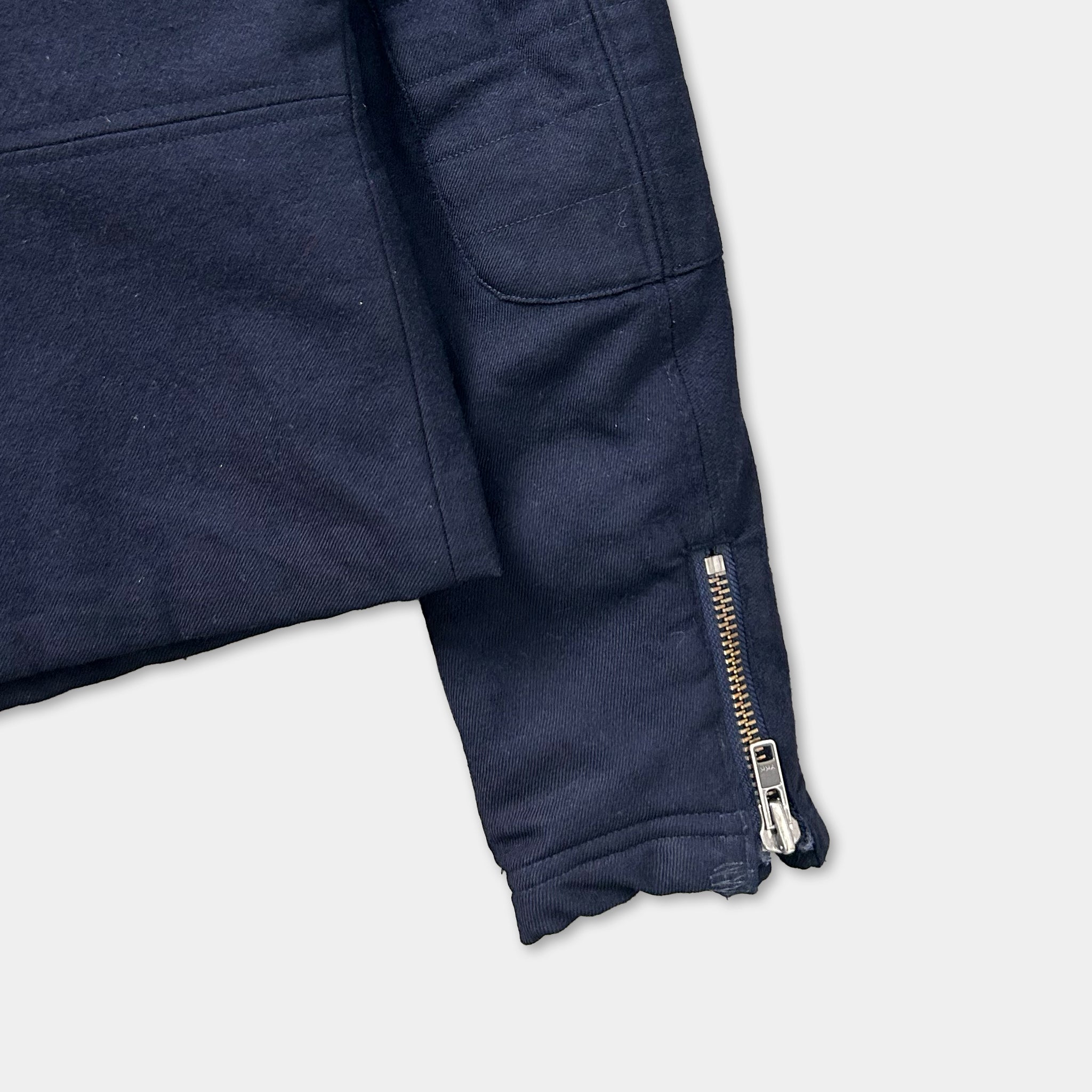 A close-up view of a navy blue jacket with a zipper and pocket.