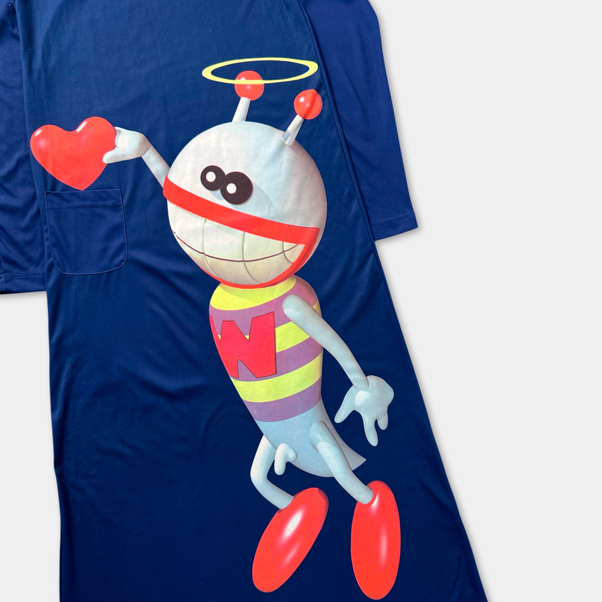 A blue t-shirt with a cartoon character printed on it, holding a red heart.