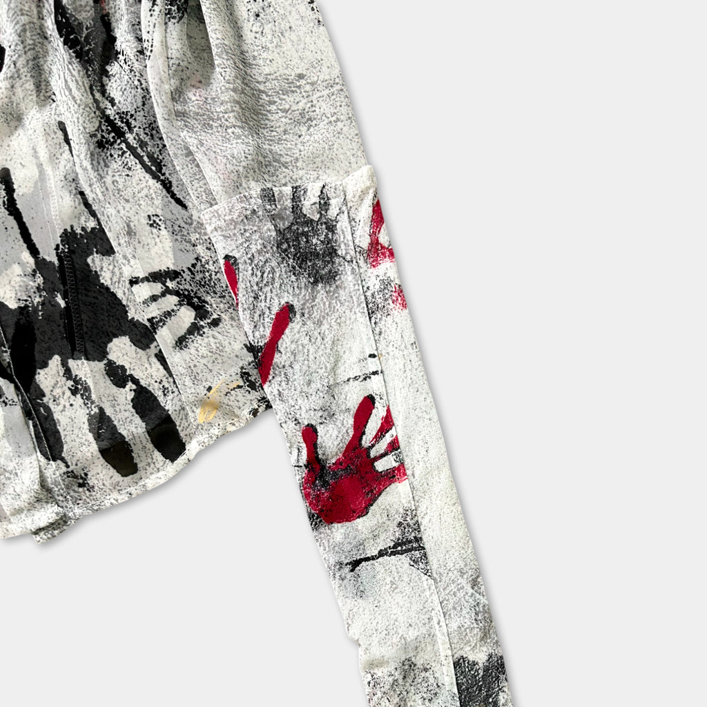 a close-up view of a fabric with a black and white abstract design, including splatters of red and black paint.