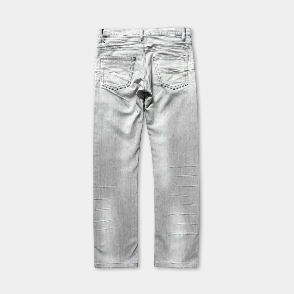 A pair of gray jeans with visible signs of wear and tear, including creases and folds in the fabric.
