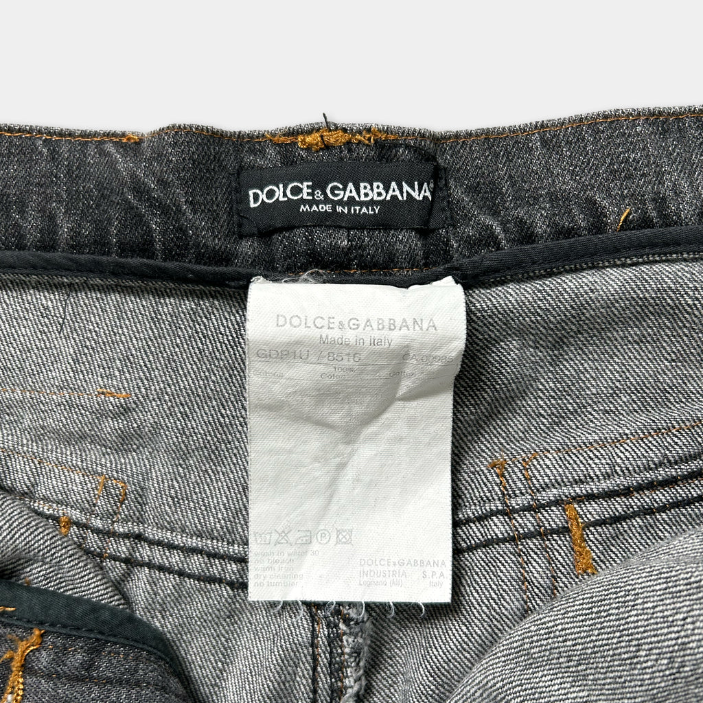 a close-up view of a pair of gray denim jeans with a label attached to the waistband.