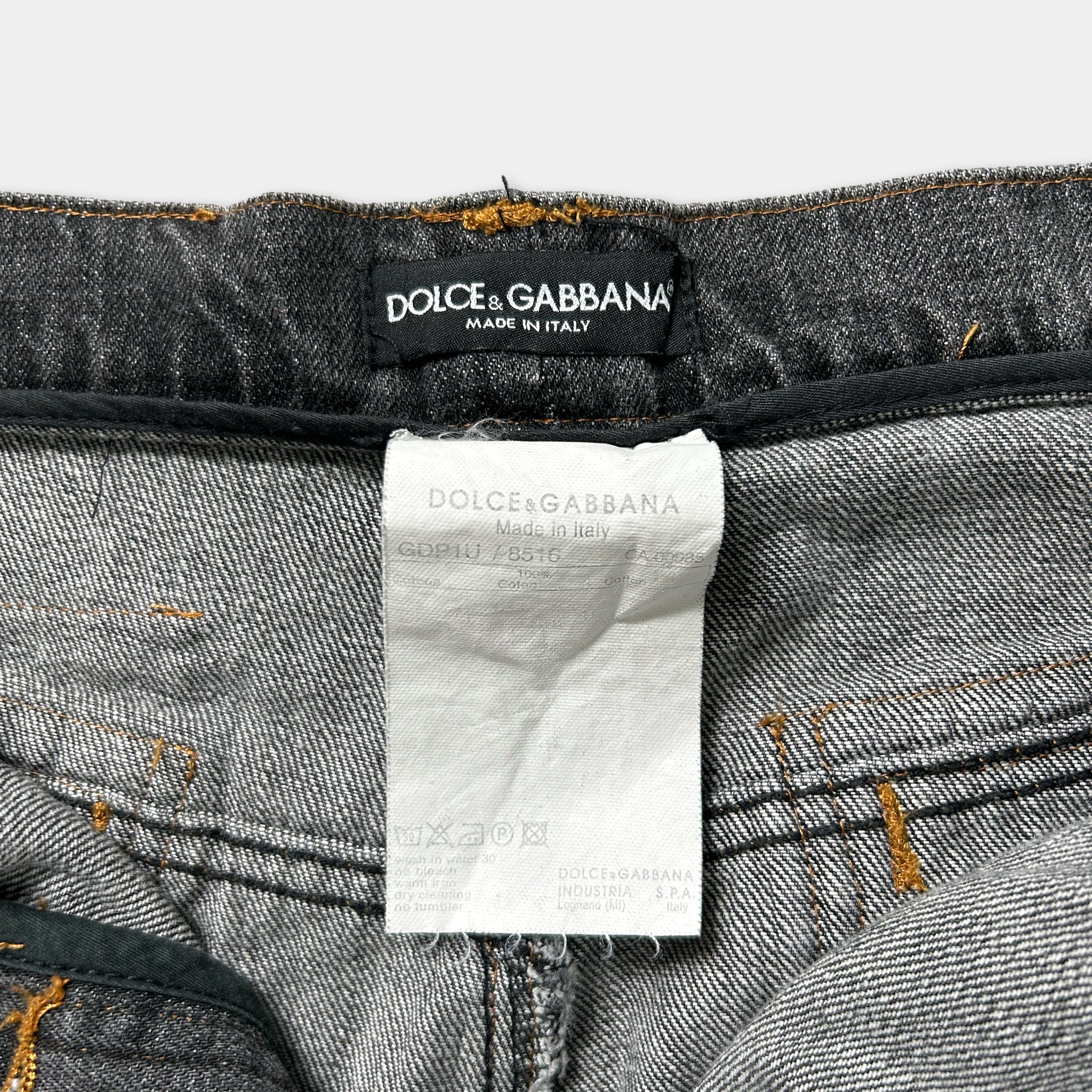 a close-up view of a pair of gray denim jeans with a label attached to the waistband.