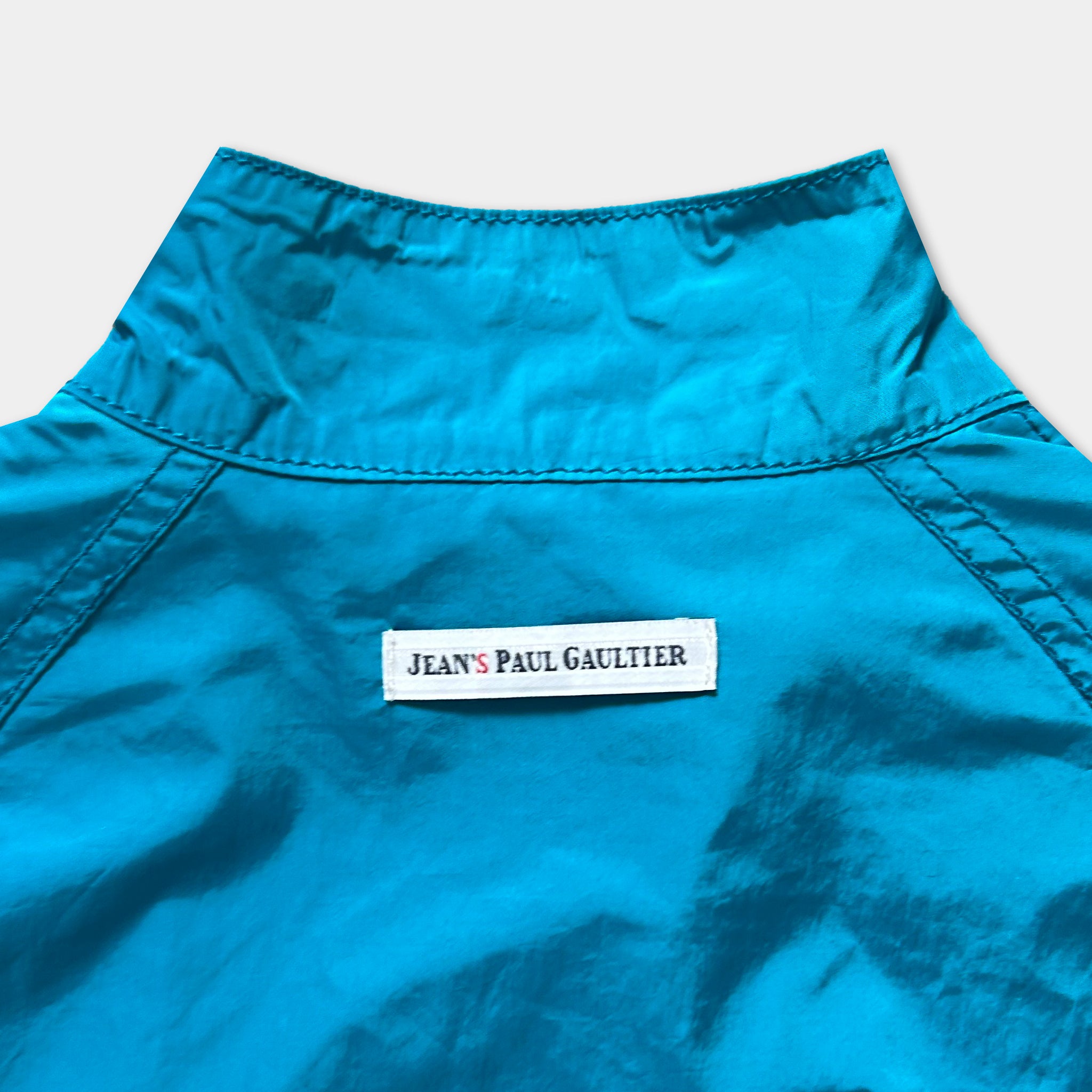 A close-up view of a bright blue jacket with a label on the back.