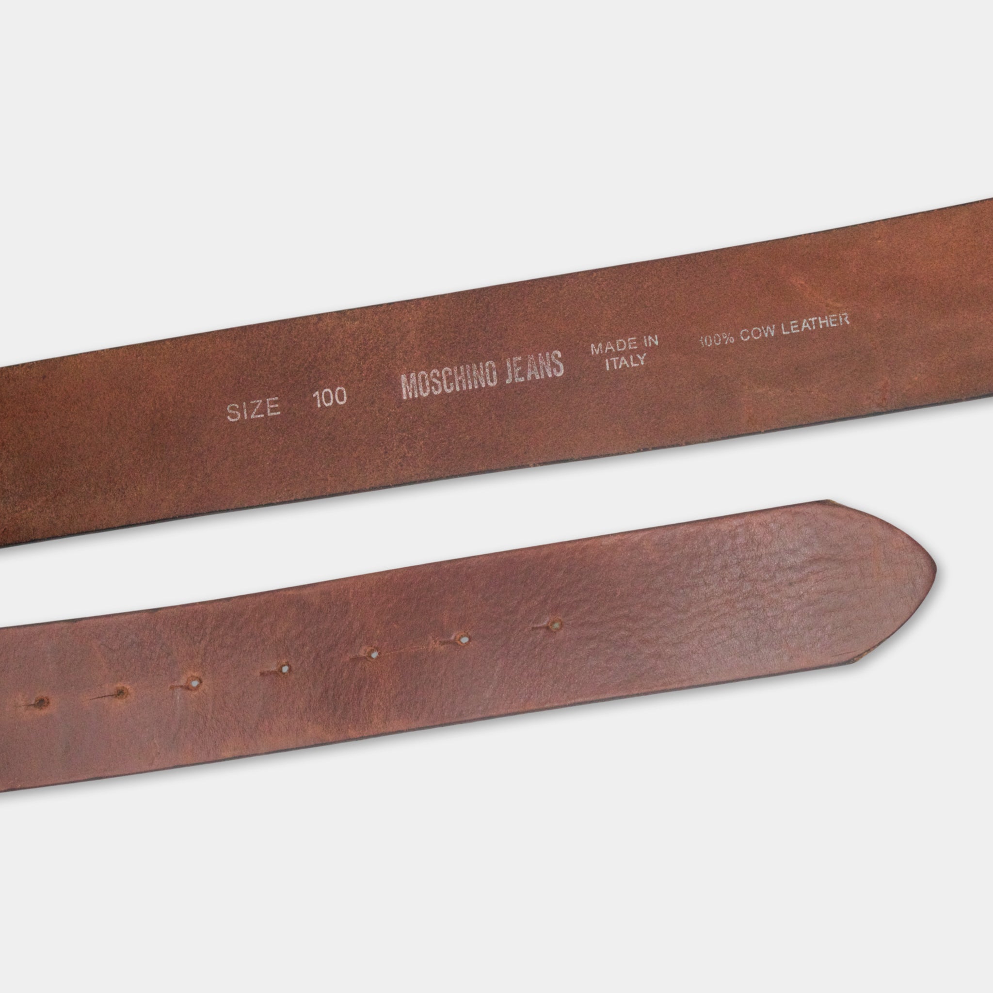 A close-up view of a brown leather belt with text printed on it.