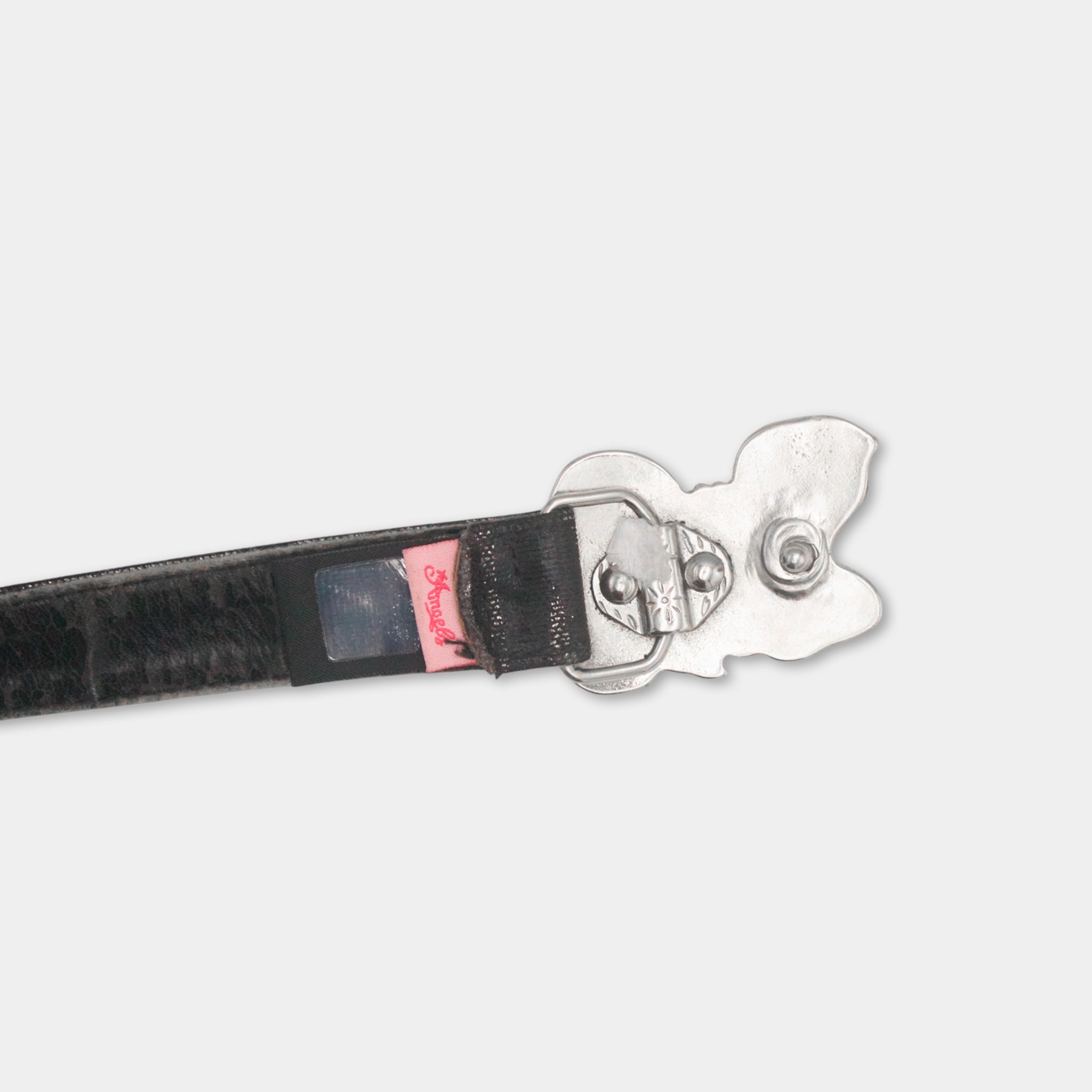A black leather belt with a silver buckle and a small red label attached to it.