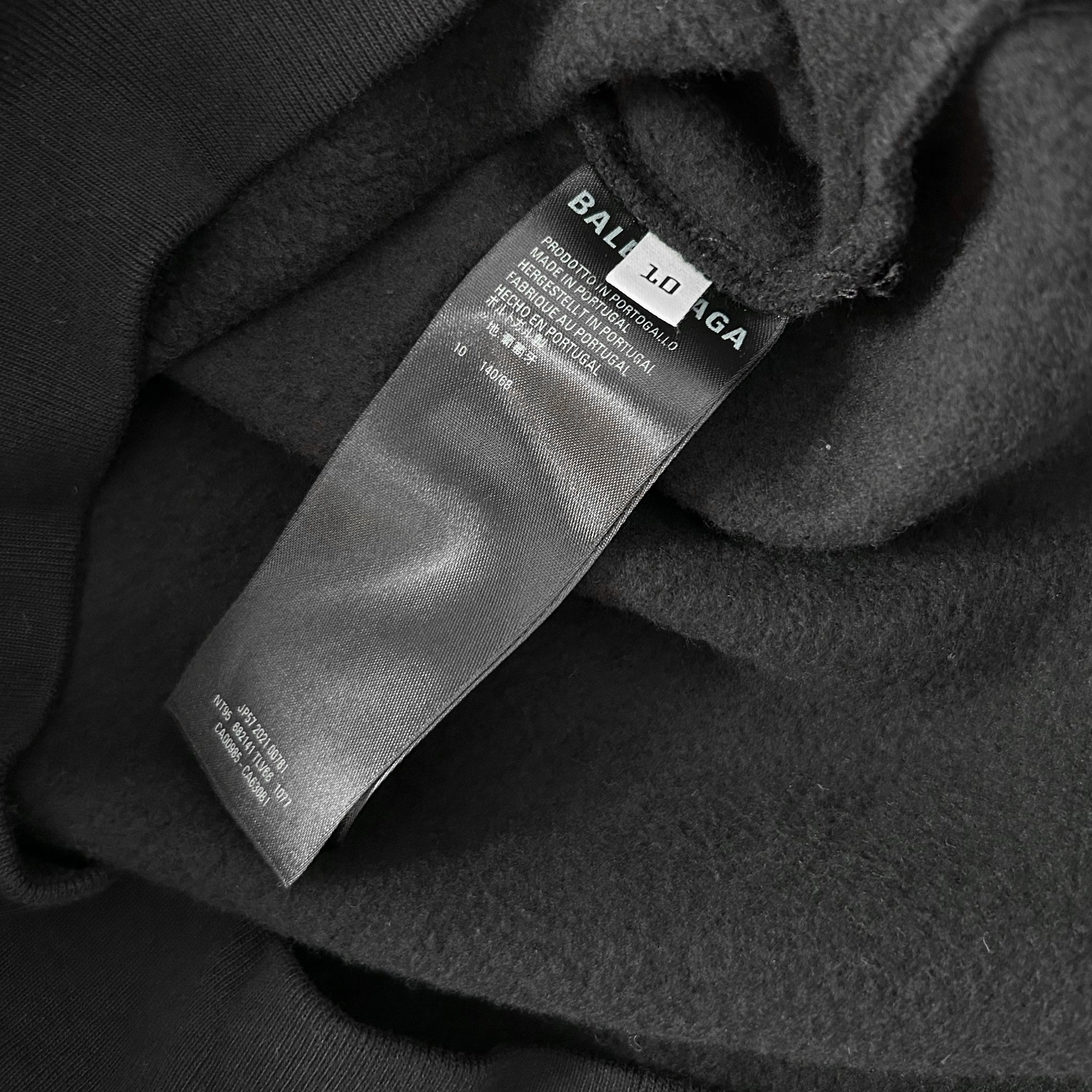 A close-up view of a black fabric with a label attached to it, which appears to be a garment or textile product.