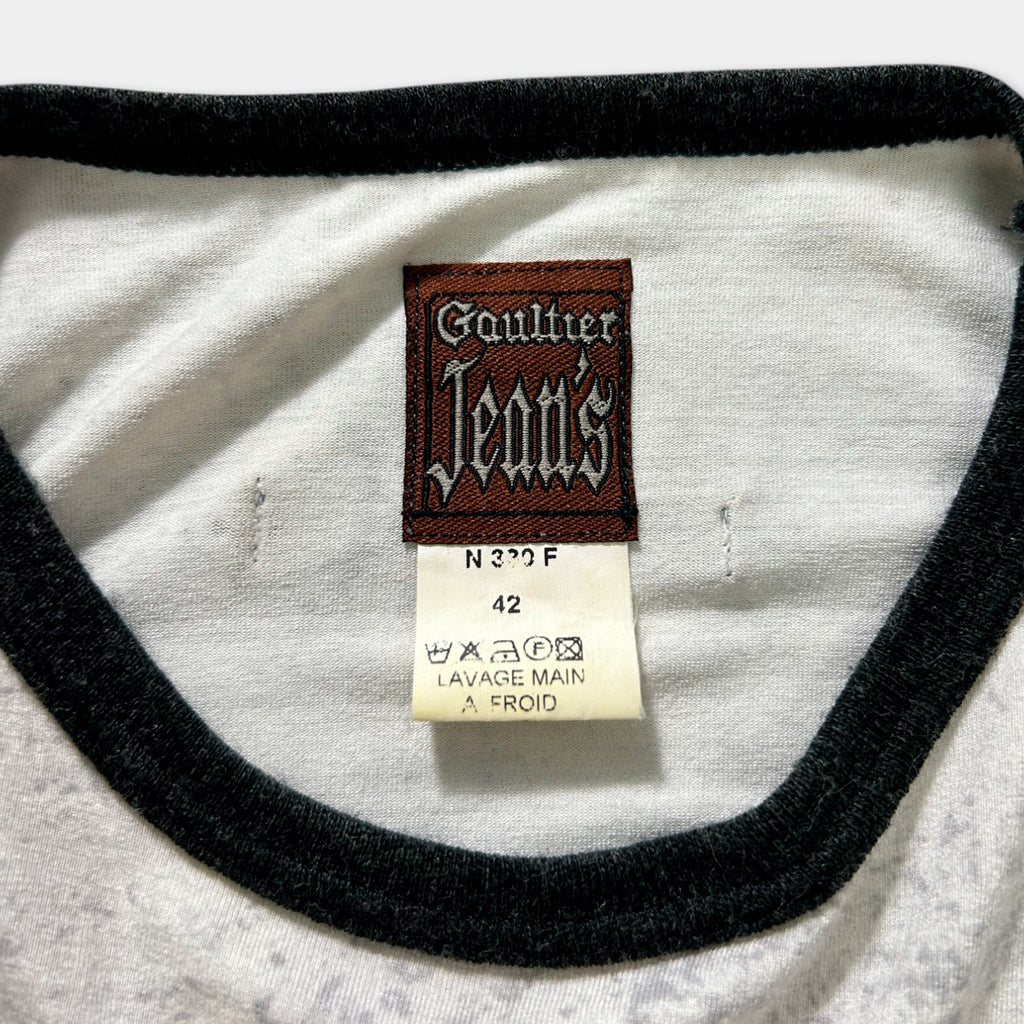 a close-up view of a white t-shirt with a black collar and a label attached to it.