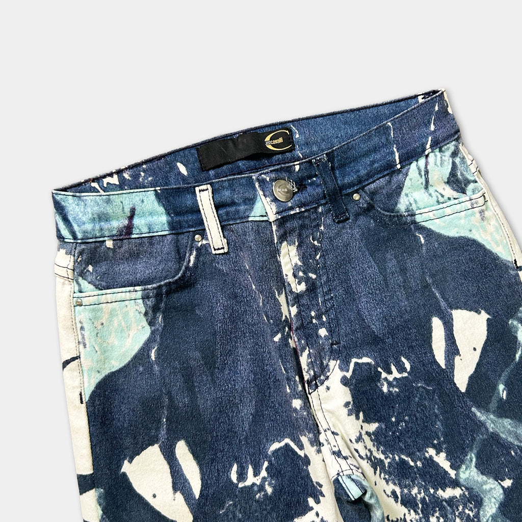 A pair of blue jeans with a unique, abstract pattern in shades of blue and white.