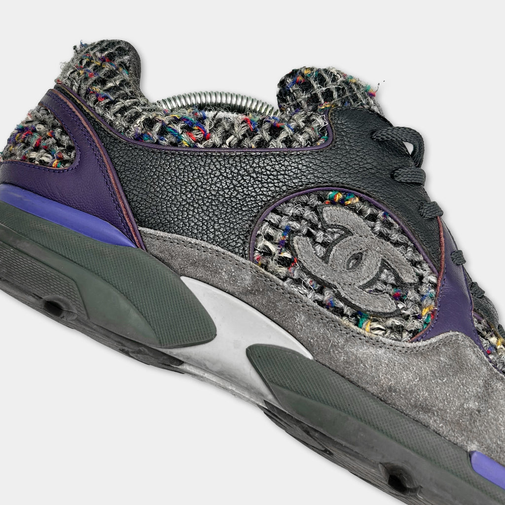 A close-up of a Chanel sneaker with a distinctive patterned design and a prominent Chanel logo.