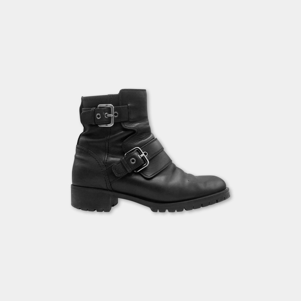 A black leather boot with metal buckles and a chunky sole.