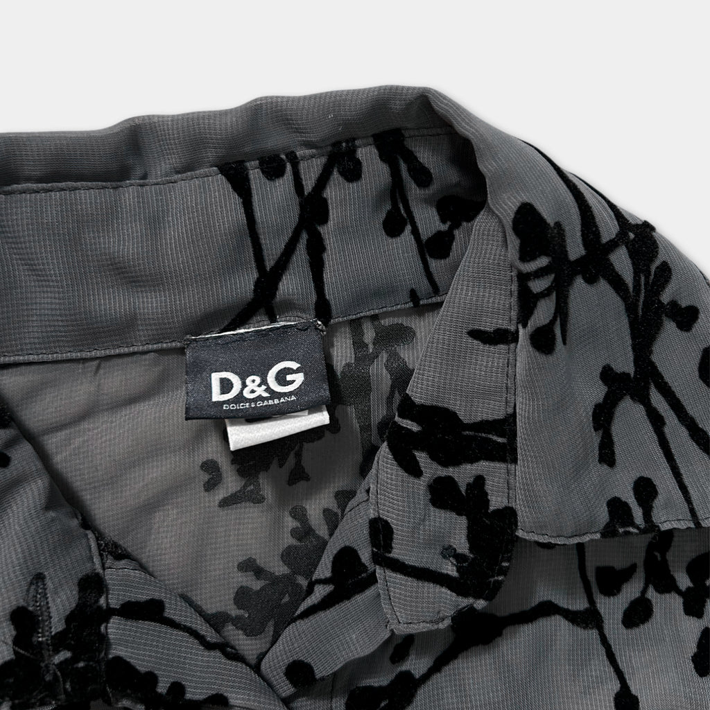 a close-up view of a collar and a tag on a gray fabric with a black floral pattern.