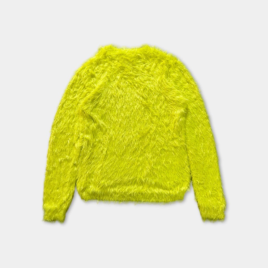 A bright yellow, furry sweater is shown against a white background.