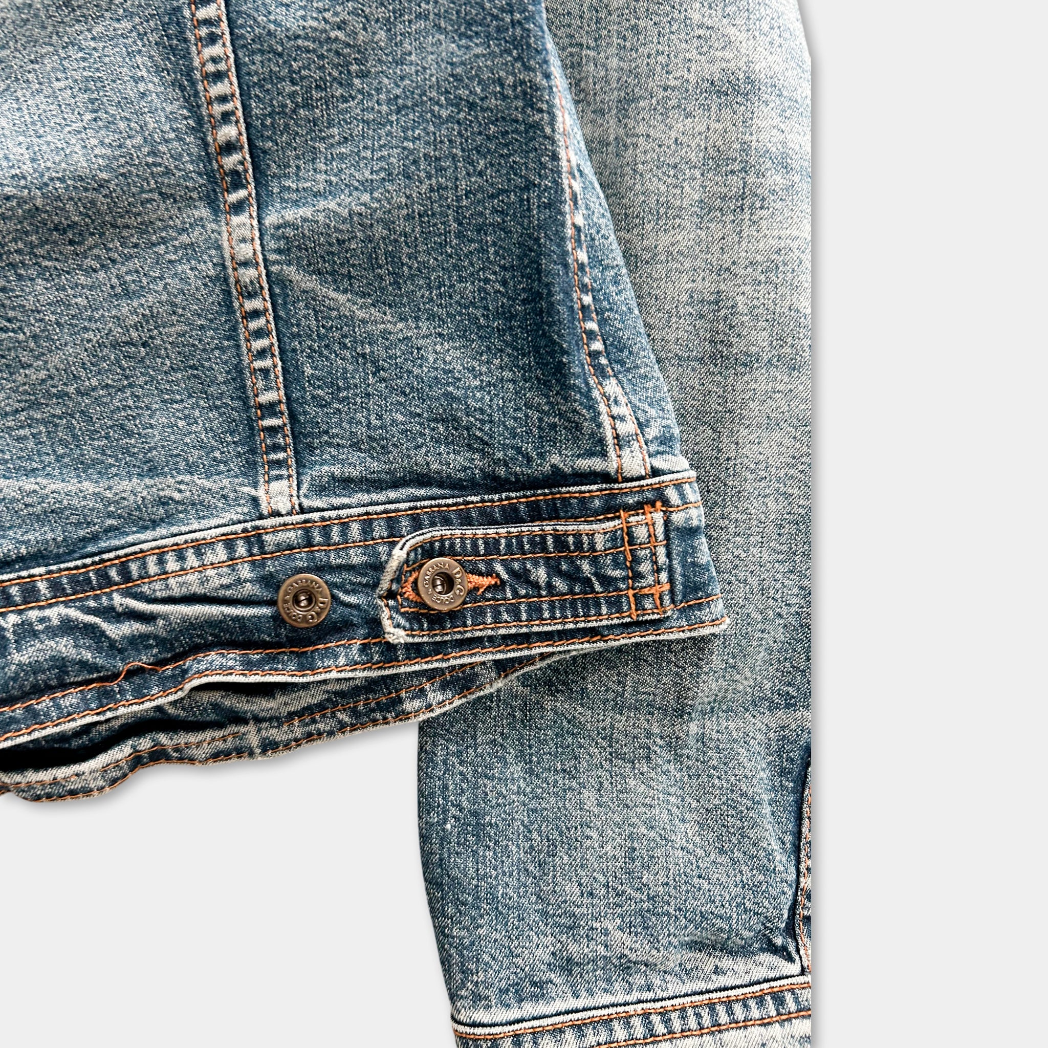 A close-up view of a pair of blue denim jeans, focusing on the zipper and belt detail.