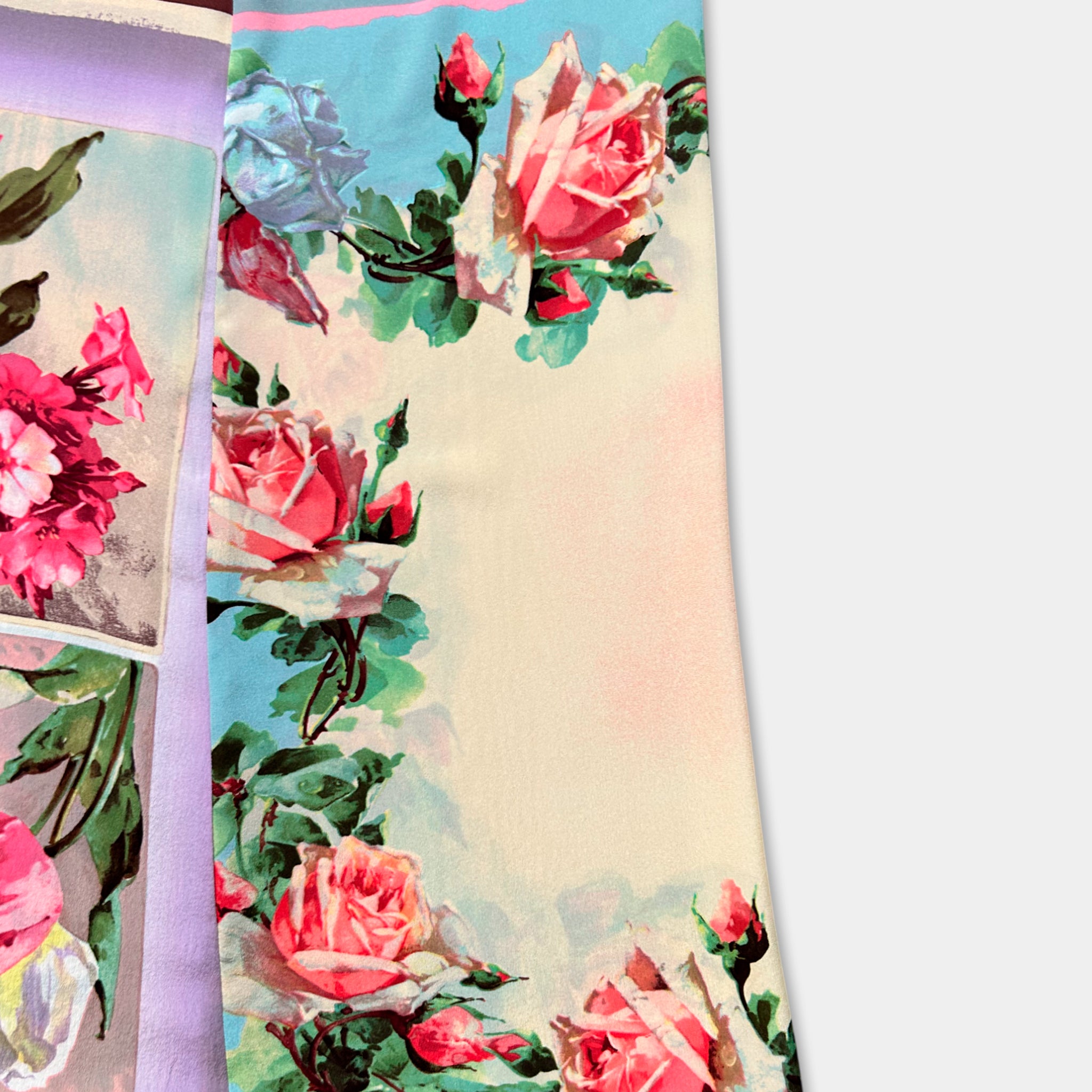 a vibrant floral print with pink and red roses, along with green leaves, creating a visually appealing and colorful design.